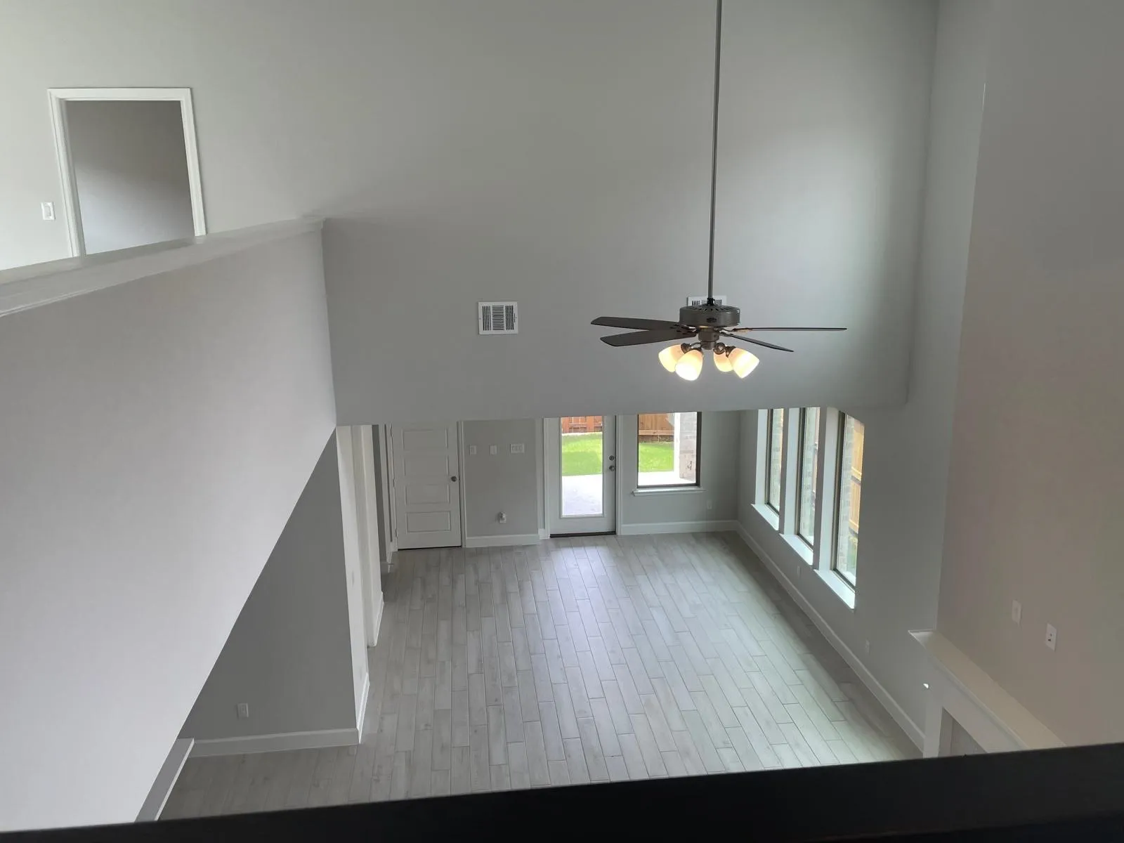 Entryway featuring light wood-type flooring, a high ceiling, and ceiling fan
