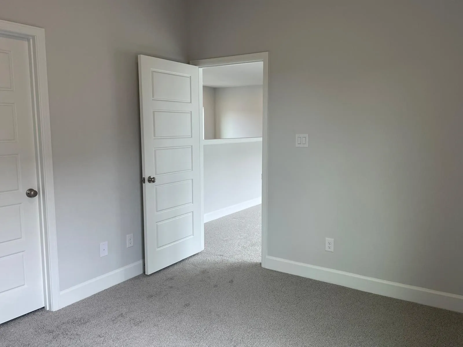 Unfurnished bedroom with light colored carpet