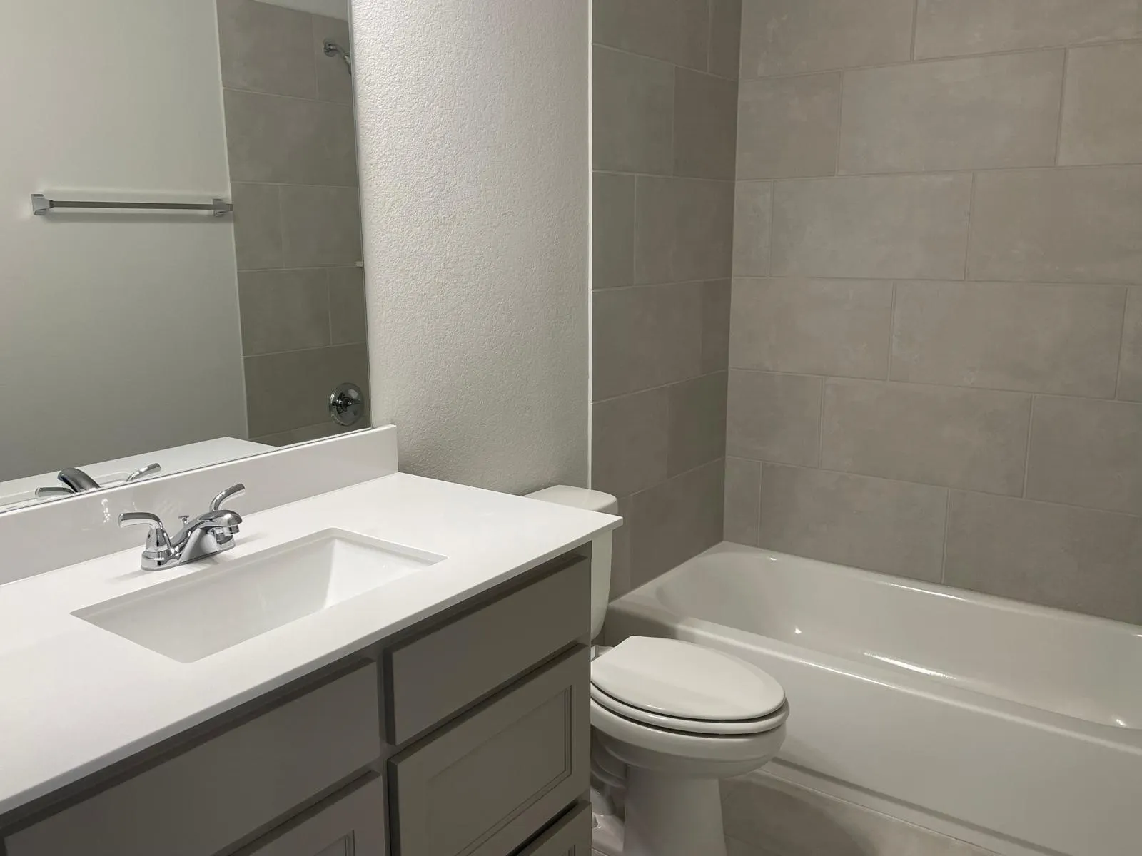 Full bathroom featuring toilet, tiled shower / bath combo, and vanity