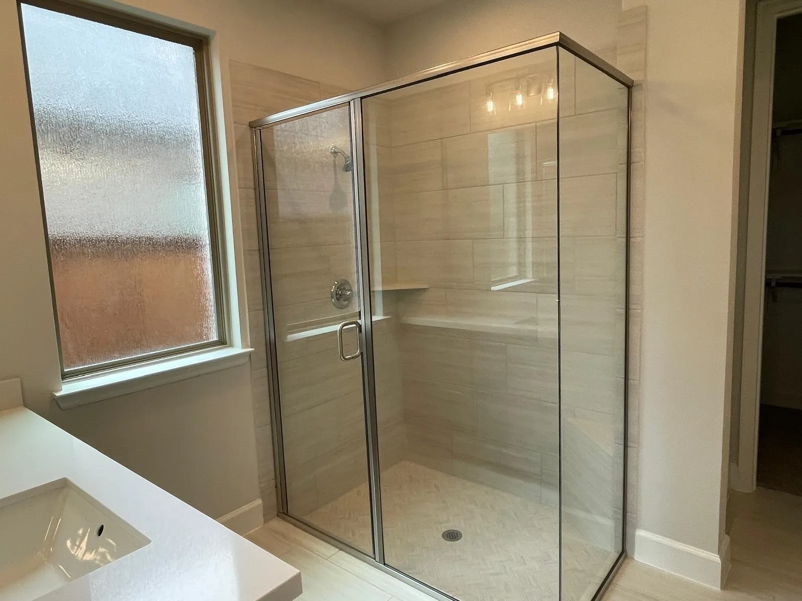 Bathroom with a healthy amount of sunlight, an enclosed shower, and vanity