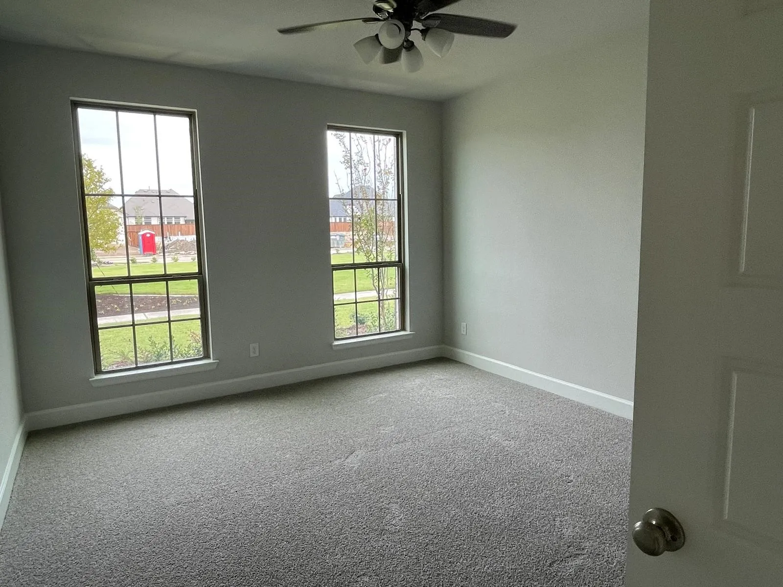 Carpeted empty room featuring ceiling fan