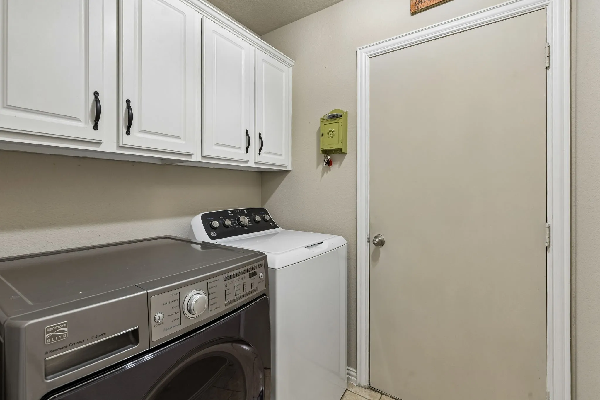 White shaker-style cabinetry with dark hardware and a neutral wall color