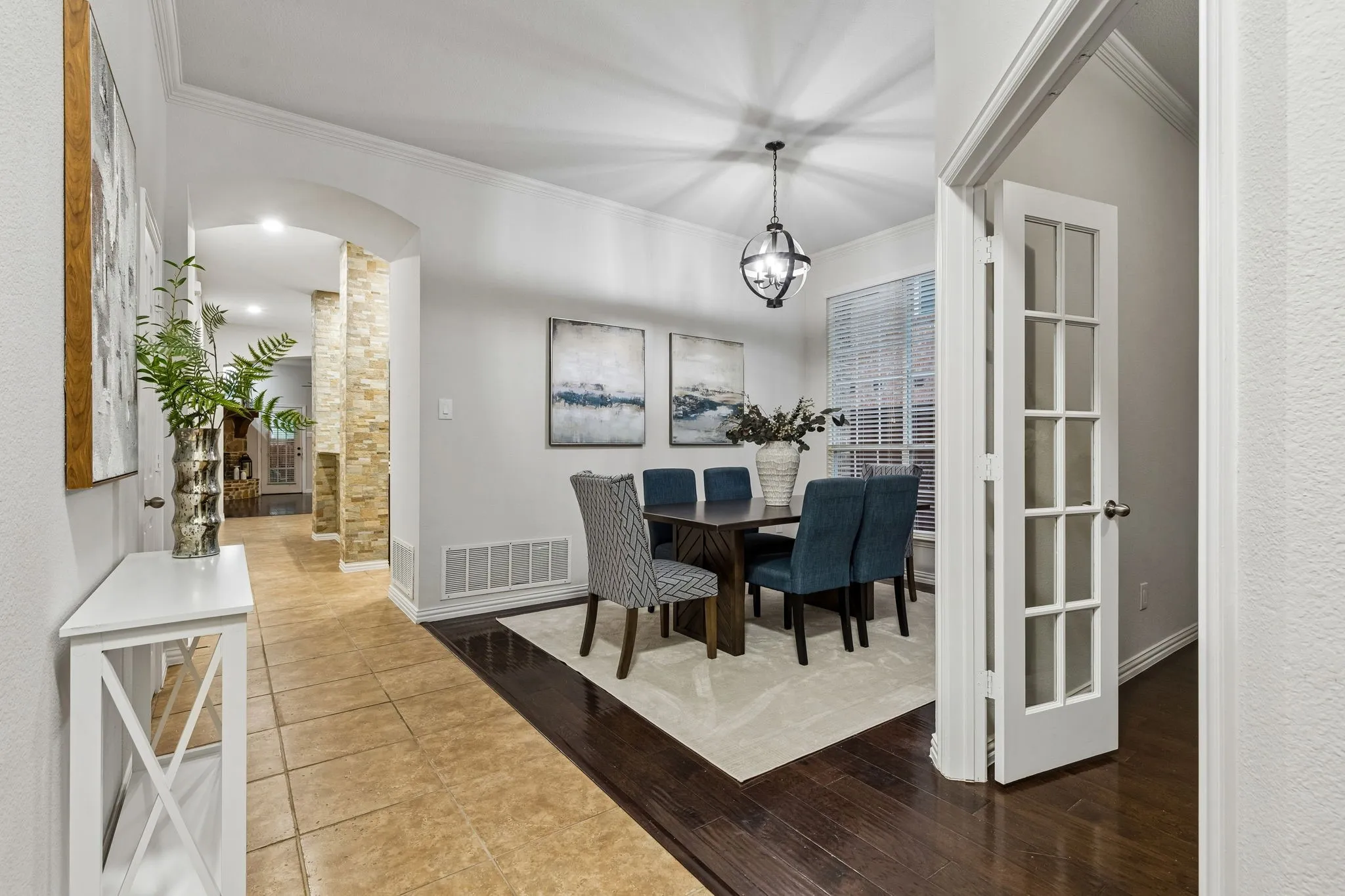 Formal dining area featuring a spherical pendant light and wood-finish flooring
