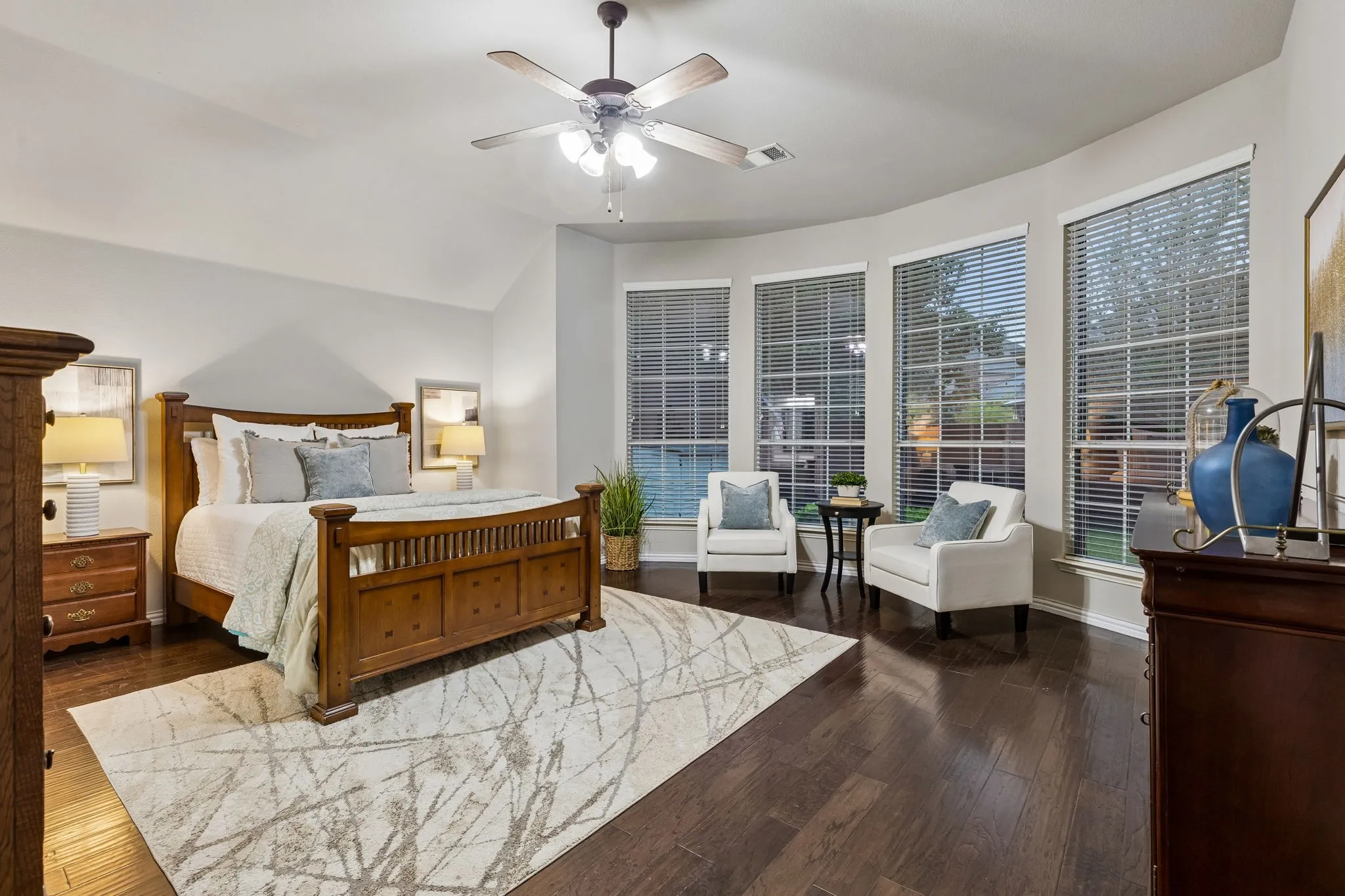Dark wood-finish flooring, vaulted ceiling, and a ceiling fan with light fixture