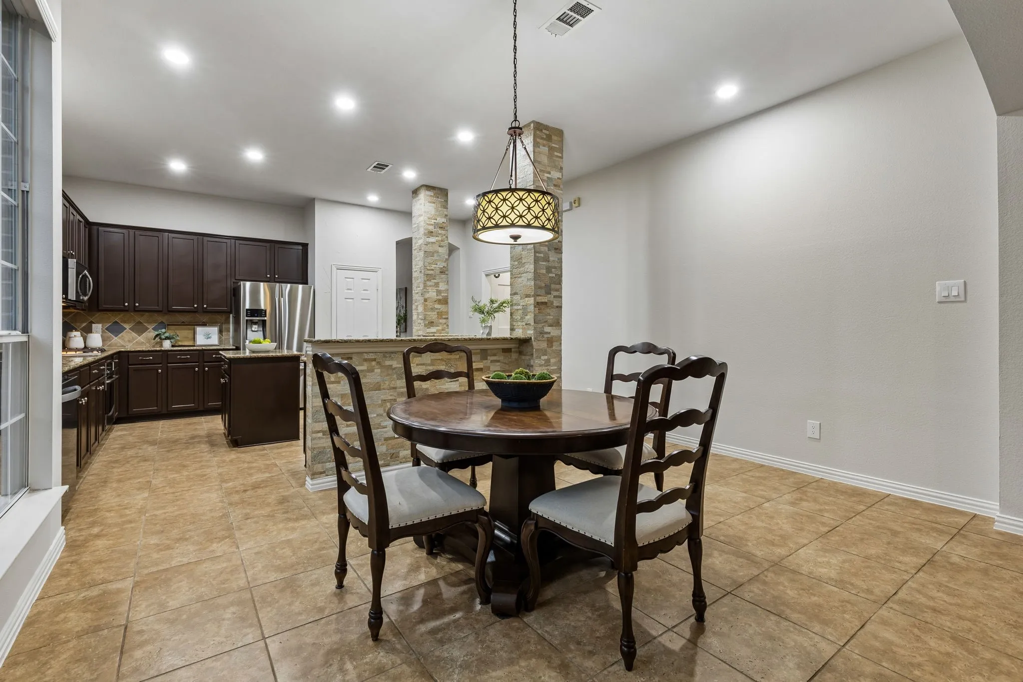 Kitchen featuring dark wood cabinetry, a tile backsplash, and stainless steel appliances