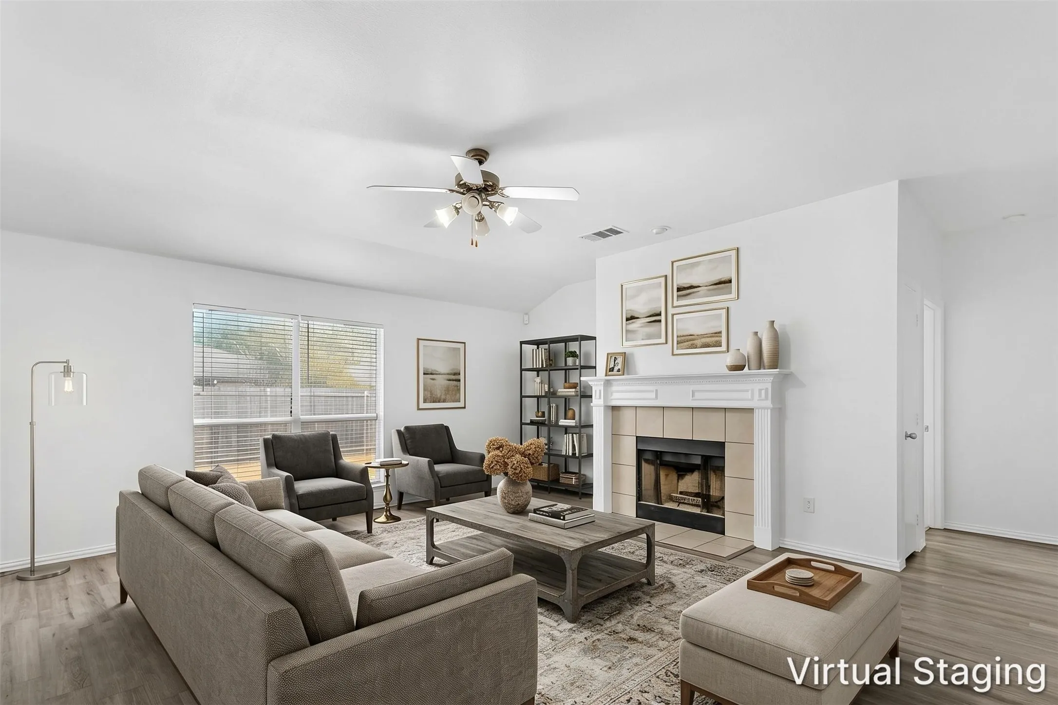 Virtually staged living room with wood-burning fireplace, ceiling fan, and a large backyard window