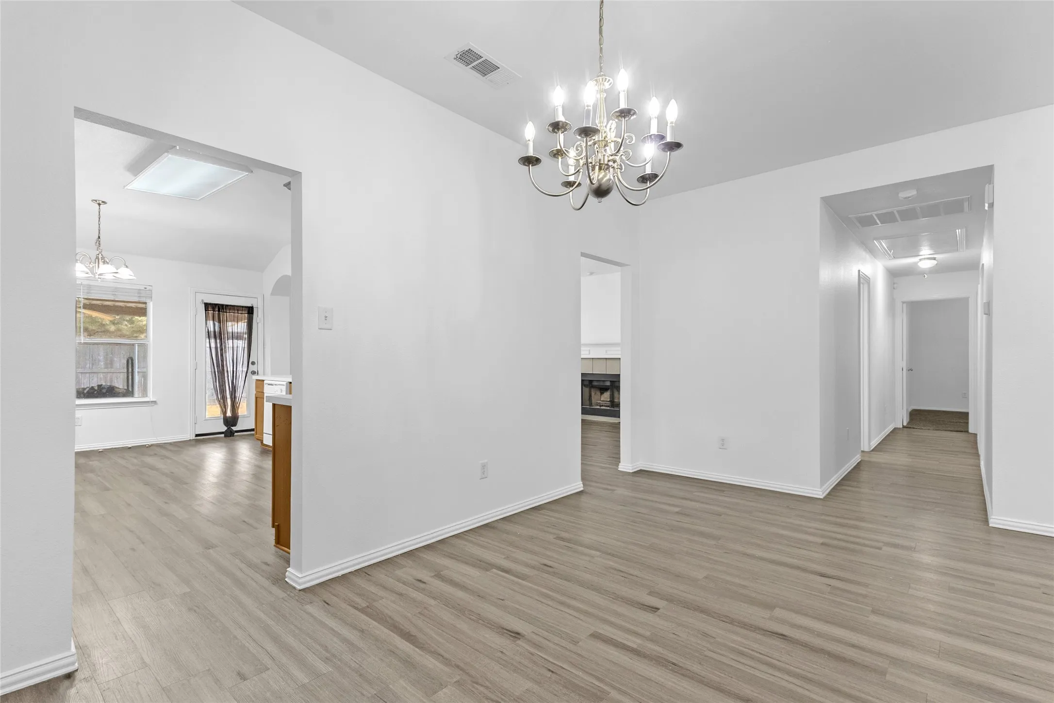 Dining room with chandelier, open to the kitchen, breakfast area, and the hallway to the bedrooms