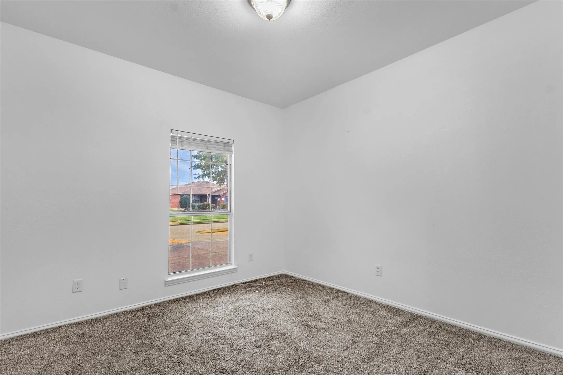 Carpeted secondary bedroom with a front-facing window in this Crandall TX home