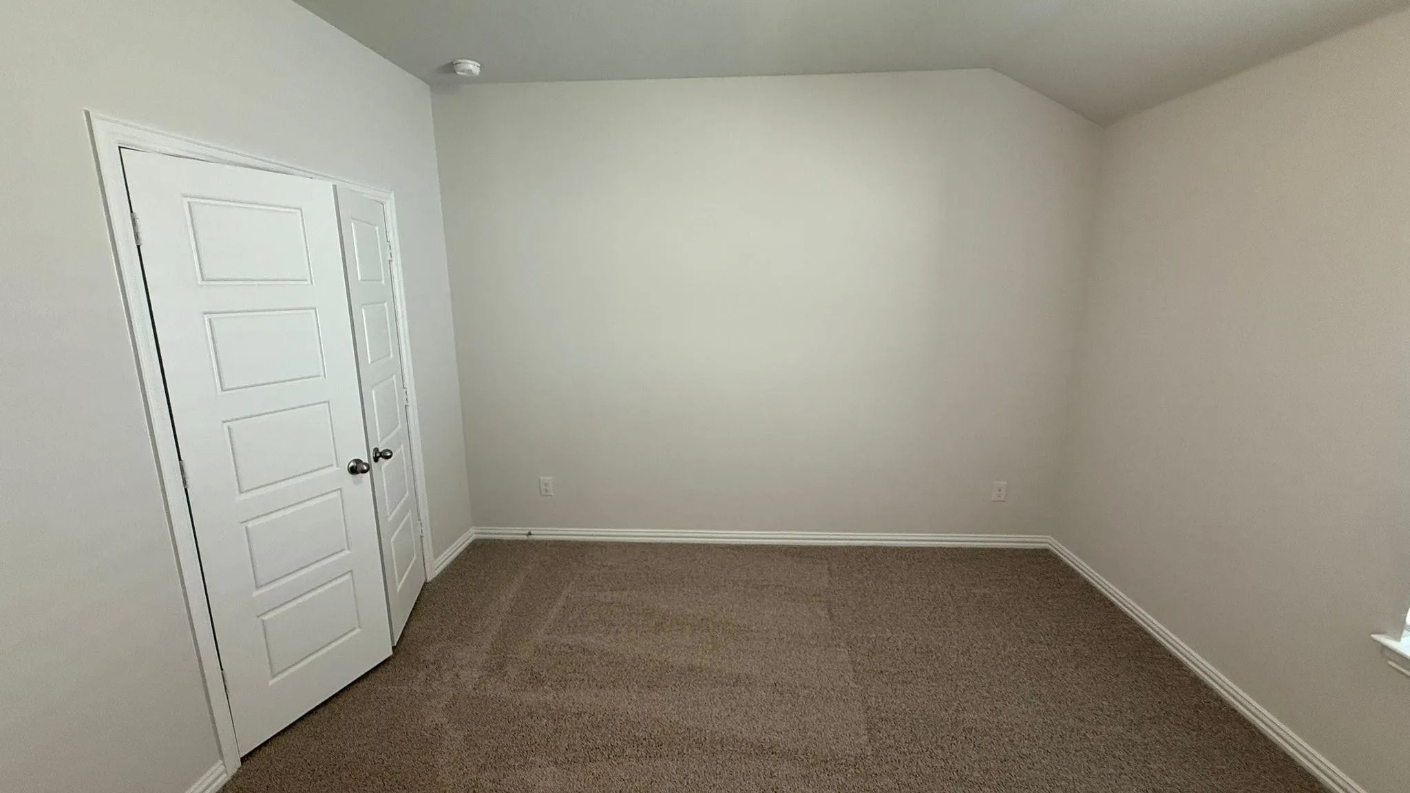 Neutral wall finishes and brown carpet flooring