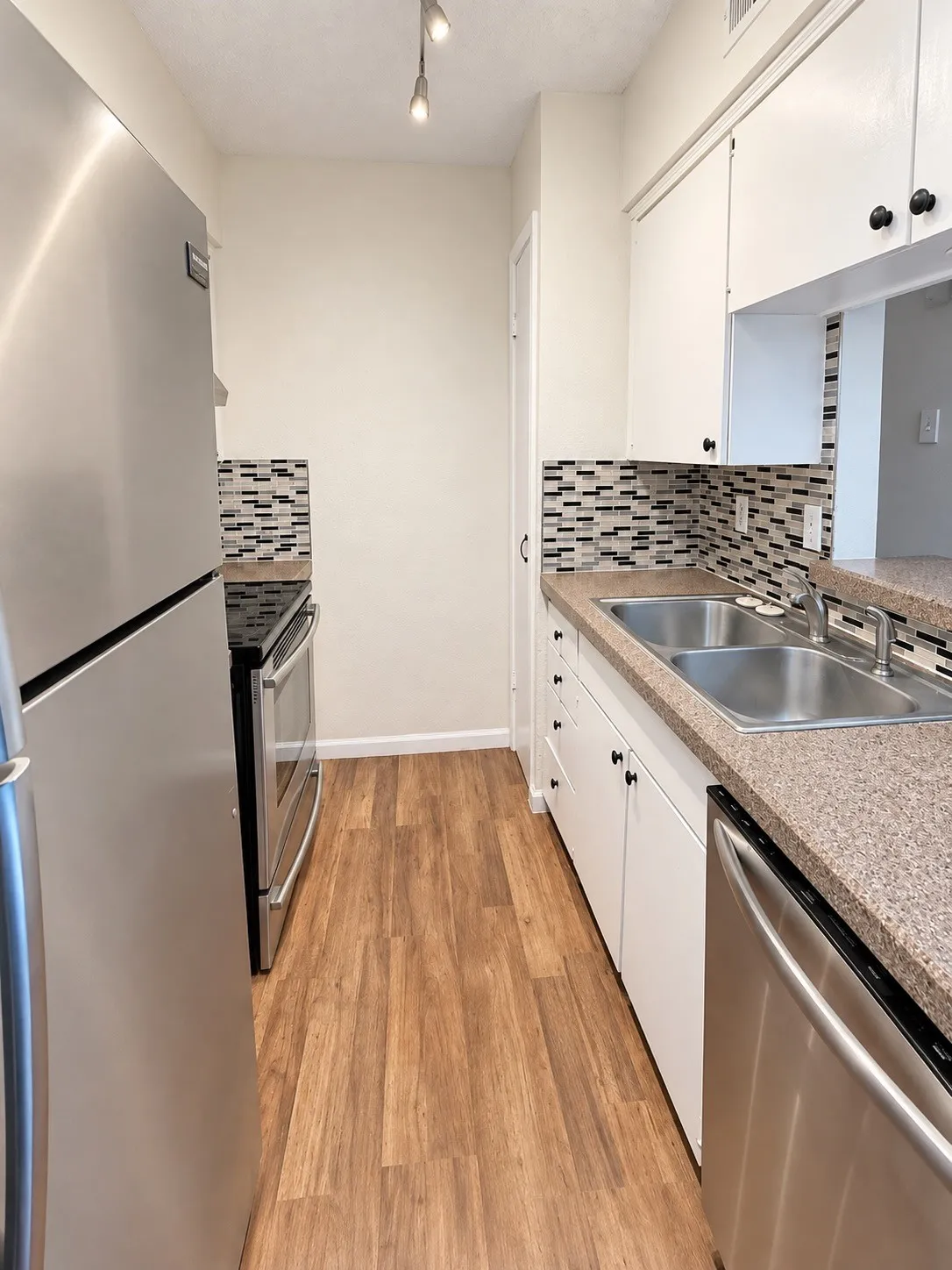 Galley kitchen with stainless appliances.