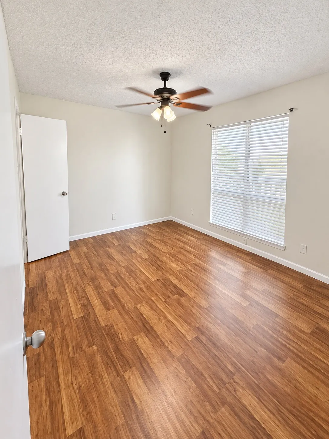 Primary bedroom with ceiling fan.