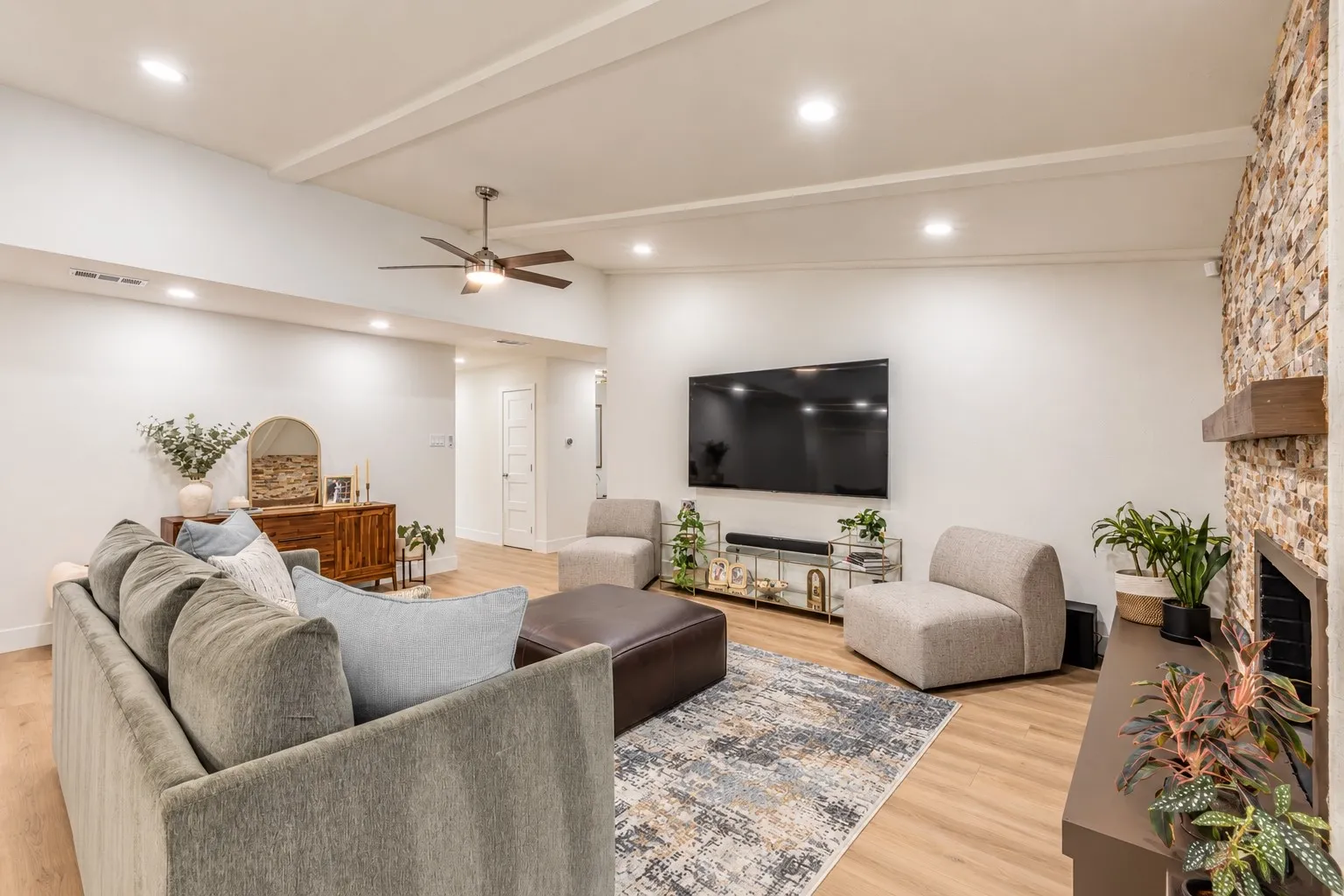 Recessed lighting, wood-finish flooring, ceiling fan, stacked stone fireplace, and a wood mantel