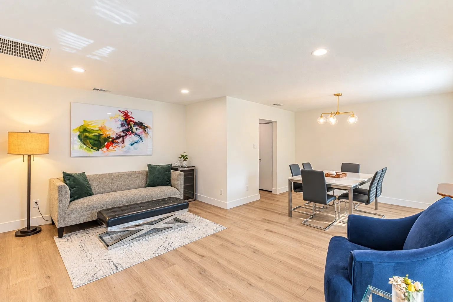 Recessed ceiling lighting, wood-finish flooring, and white baseboards