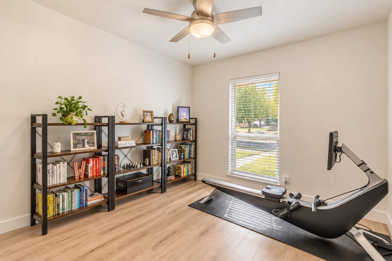 Wood-finish flooring, ceiling fan, and window with blinds