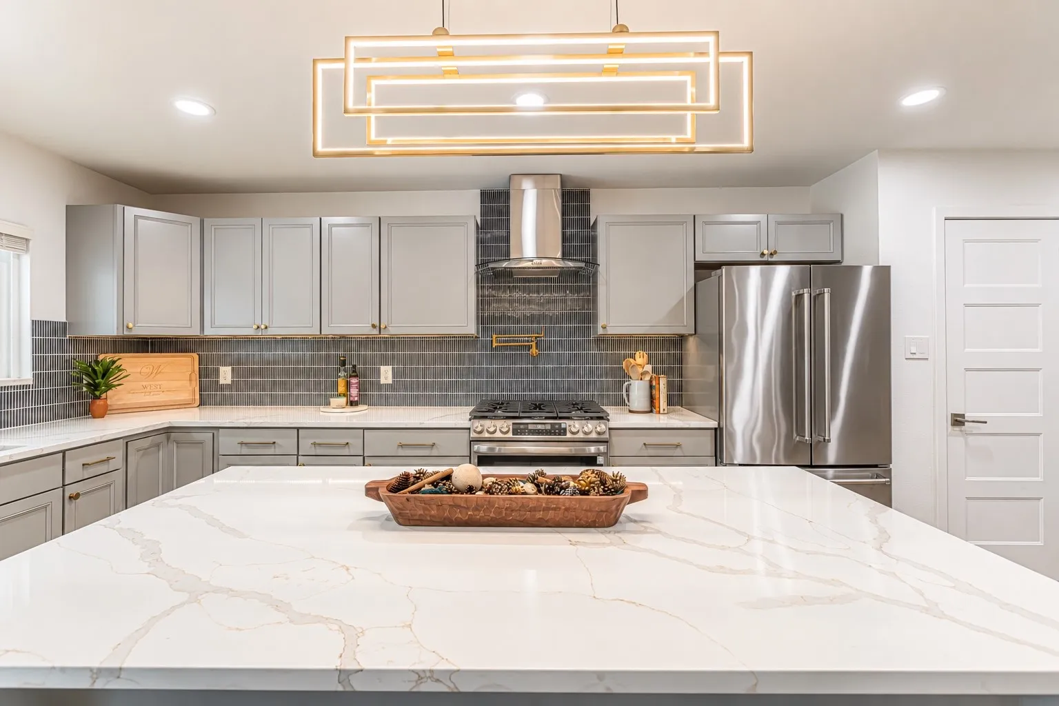 Spacious kitchen featuring an expansive island with a stone-finish countertop, stainless steel appliances, modern cabinetry, and recessed lighting