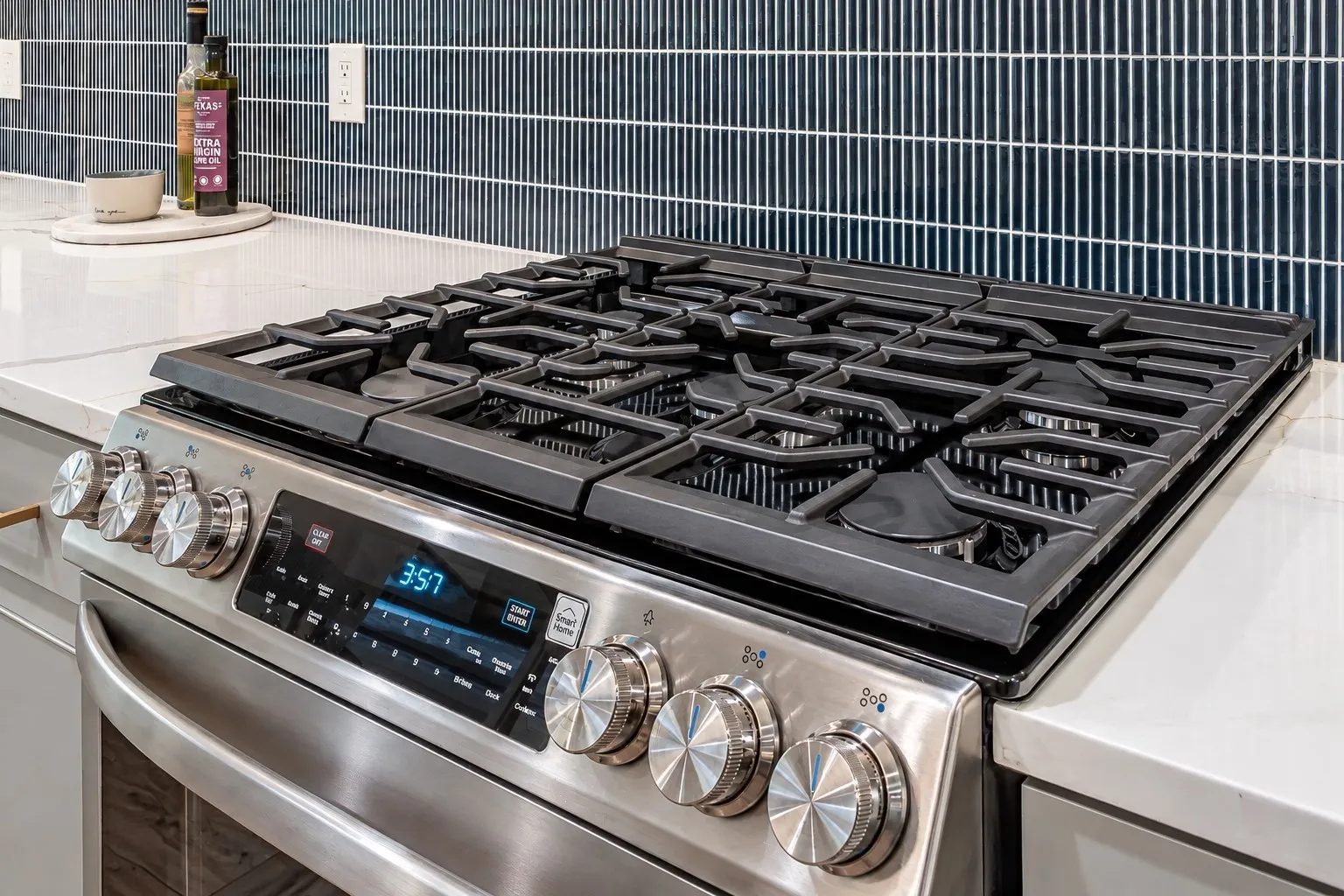 Stainless steel range with a gas cooktop, sleek control panel, and textured knobs