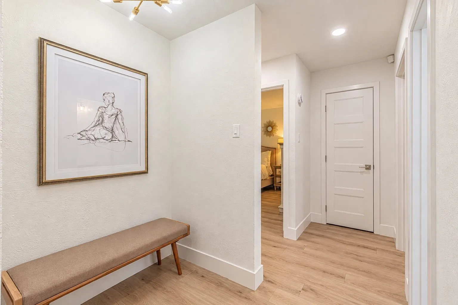 Recessed lighting, wood-finish flooring, white trim, and white interior doors