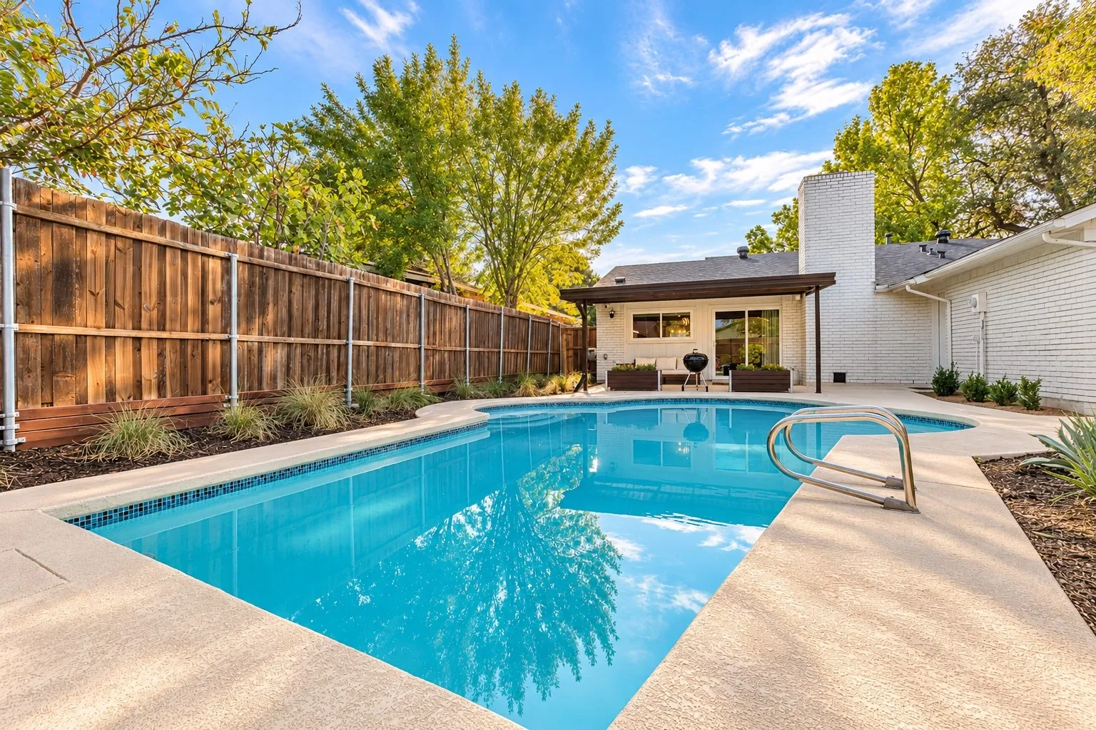 Rectangular swimming pool with integrated spa and concrete coping