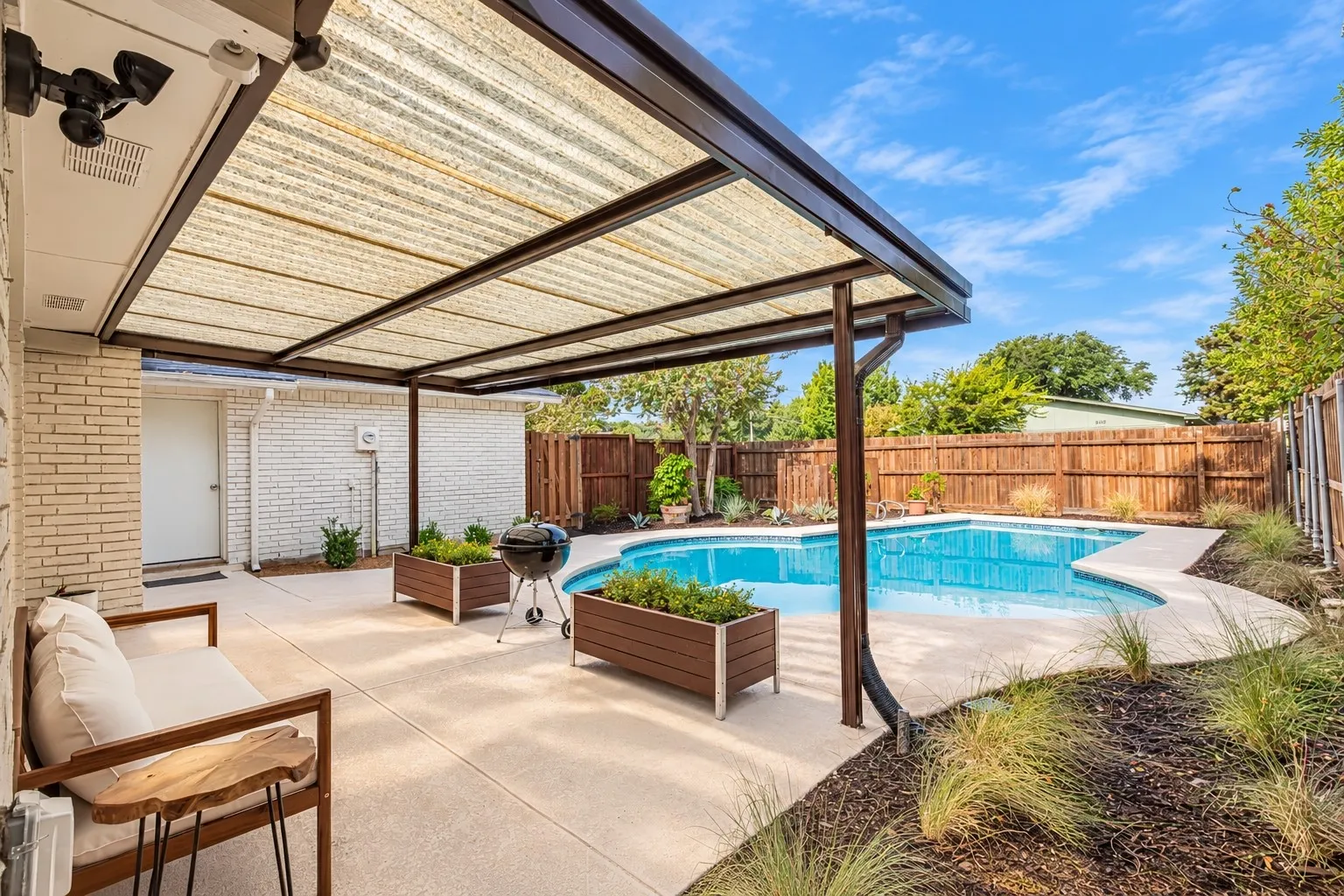 Patio with a pergola, inground swimming pool, concrete decking, and wood fencing