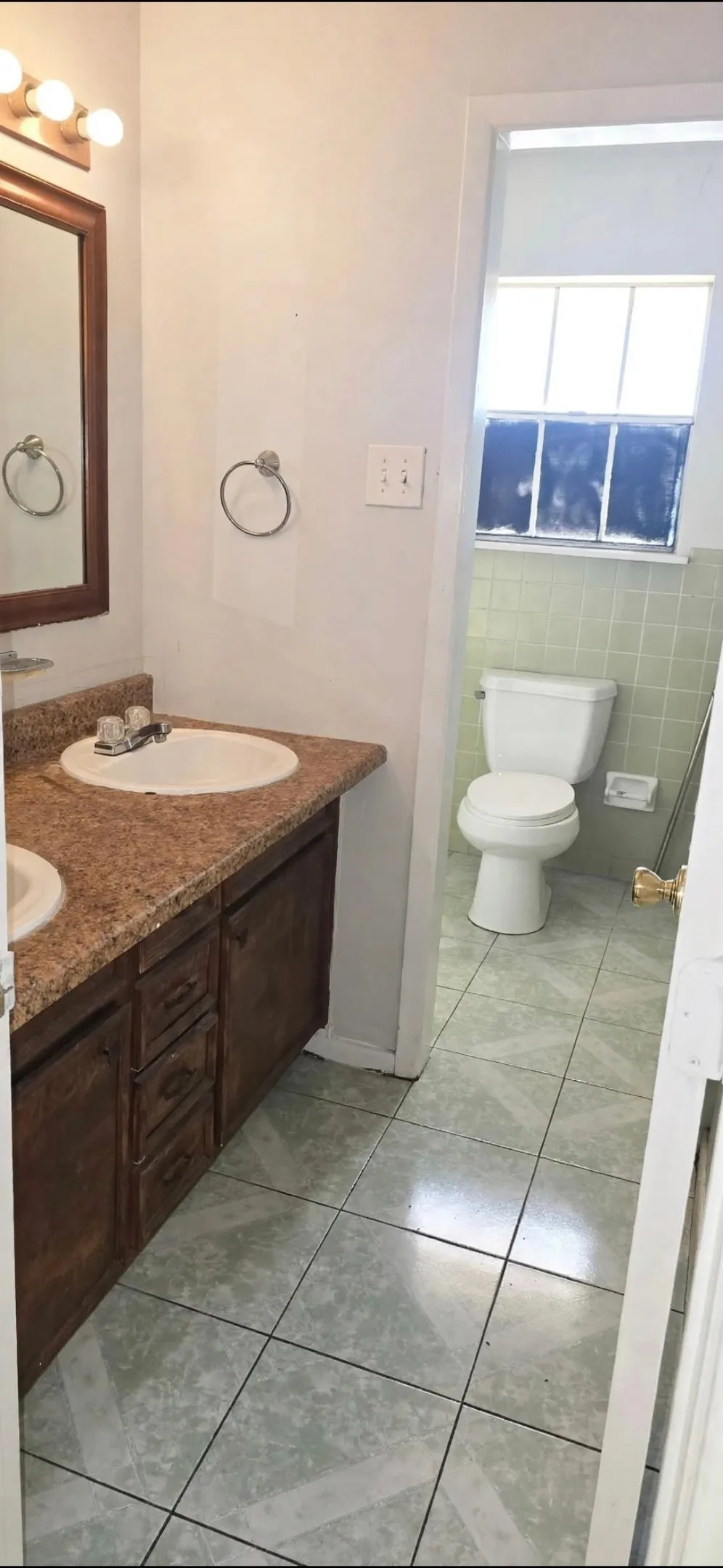 Dual basin vanity with wood cabinetry and stone-look countertop