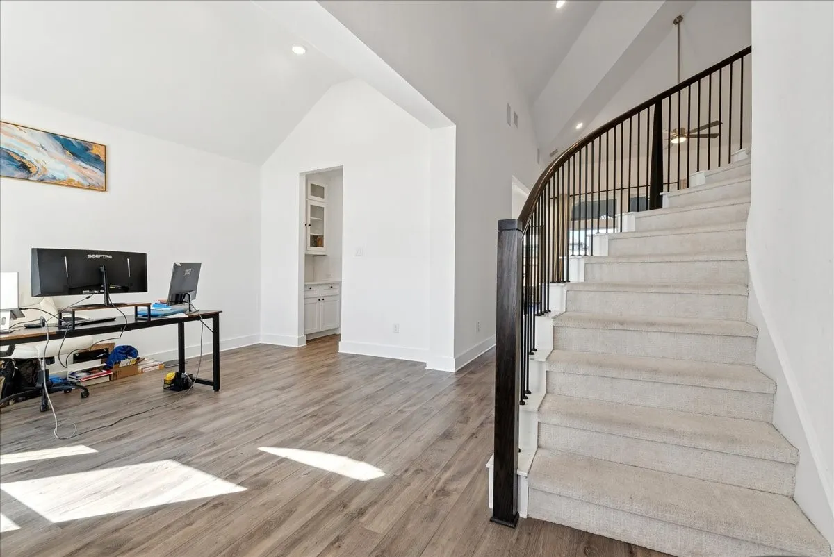 Wood-finish flooring with vaulted ceilings and recessed lighting