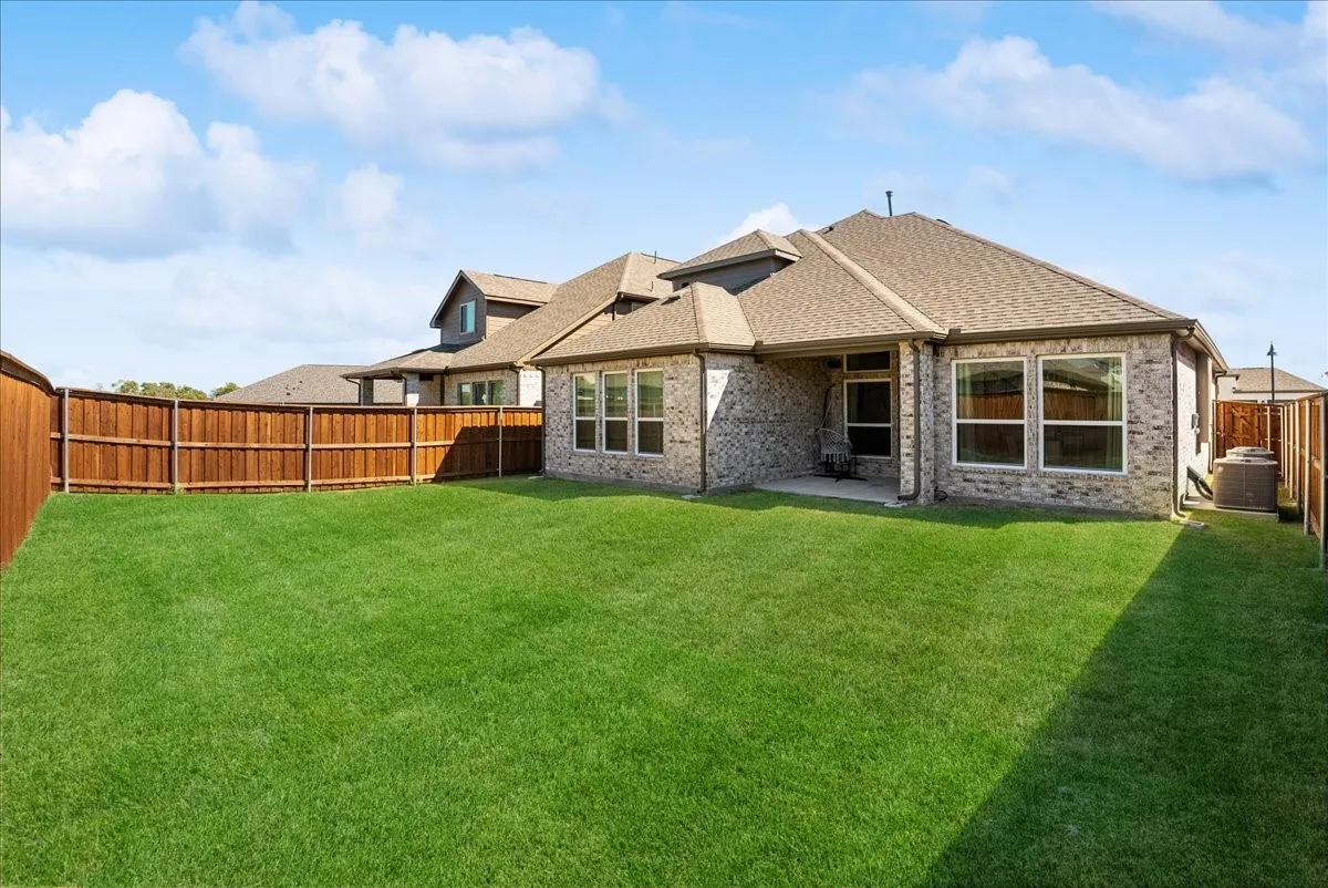 Expansive grass lawn with a full privacy fence