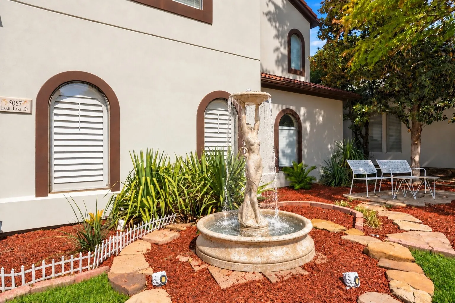 Beautiful landscaping and a charming fountain.