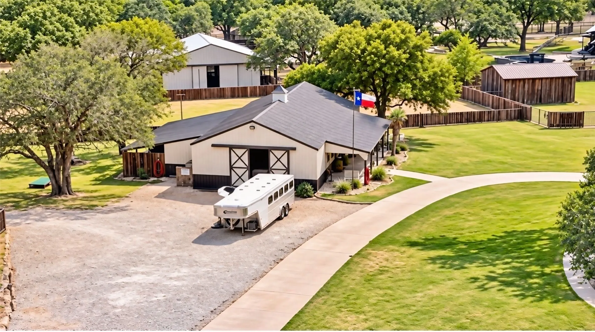 Expansive property featuring multiple structures, a paved drive, and a manicured lawn