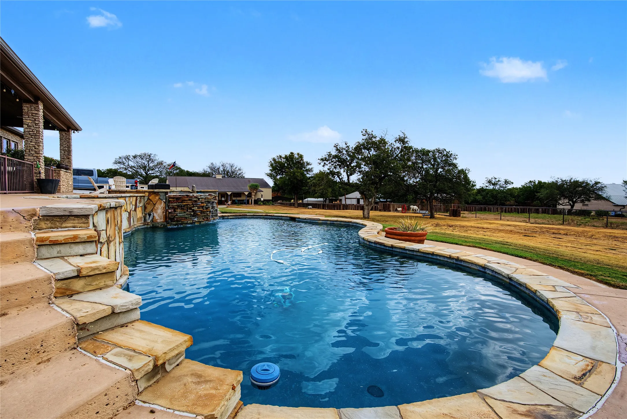 Freeform pool with stone coping and integrated stone steps