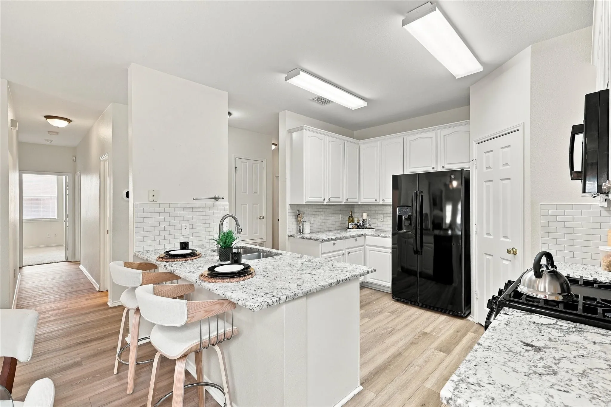 The updated kitchen has a modern, neutral appeal with crisp white cabinetry, granite countertops and a classic subway tile backsplash. Easy-to-maintain LVP flooring completes the space and keeps everyday living simple.