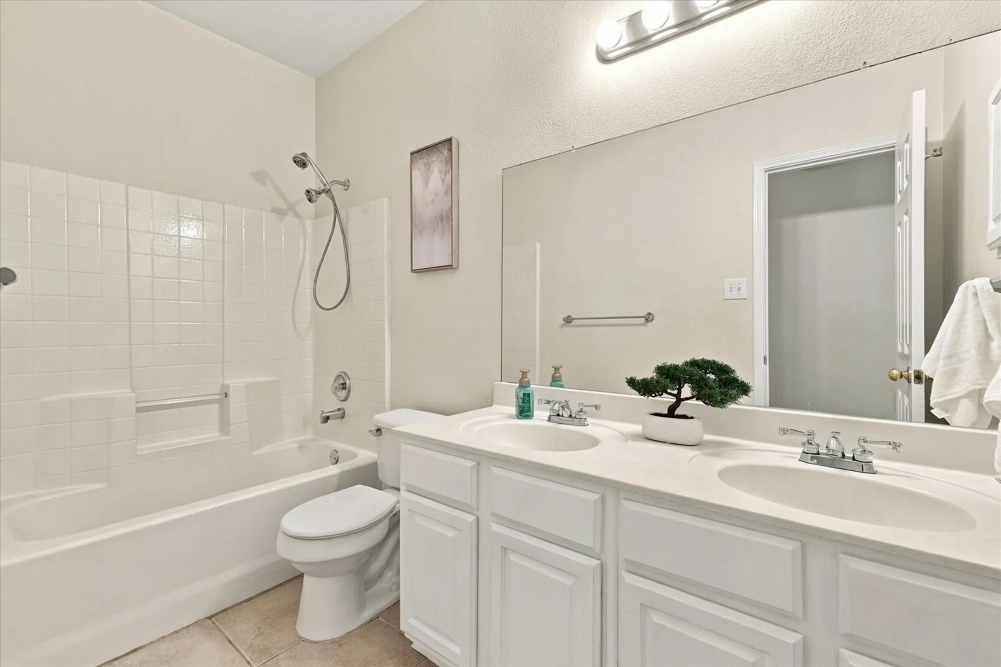 A spacious shared bathroom with dual sinks gives everyone a little more room to get ready, making busy mornings easier.
