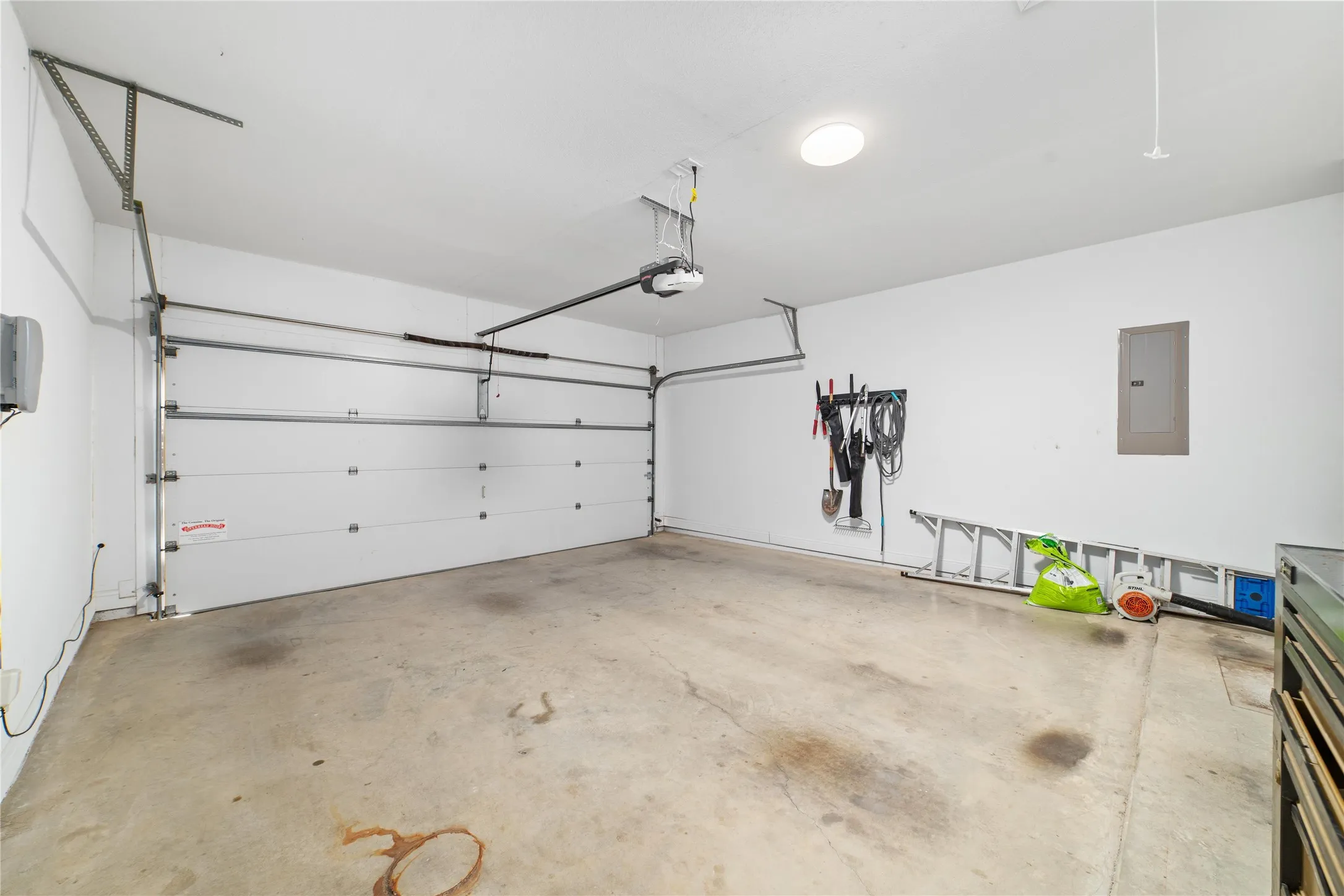 Garage featuring a garage door opener and electric panel