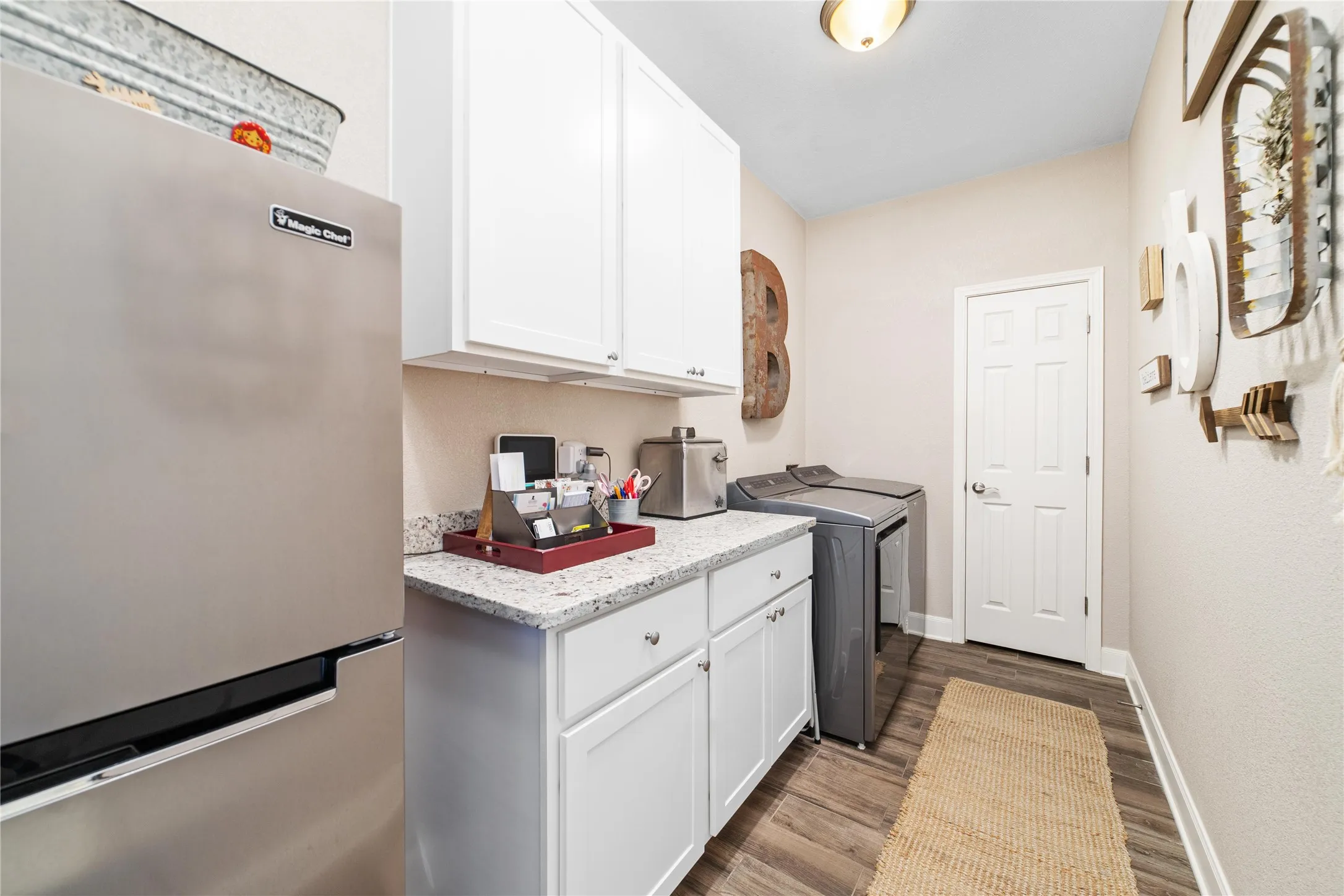 Laundry room with cabinets, wood-type flooring, and separate washer and dryer