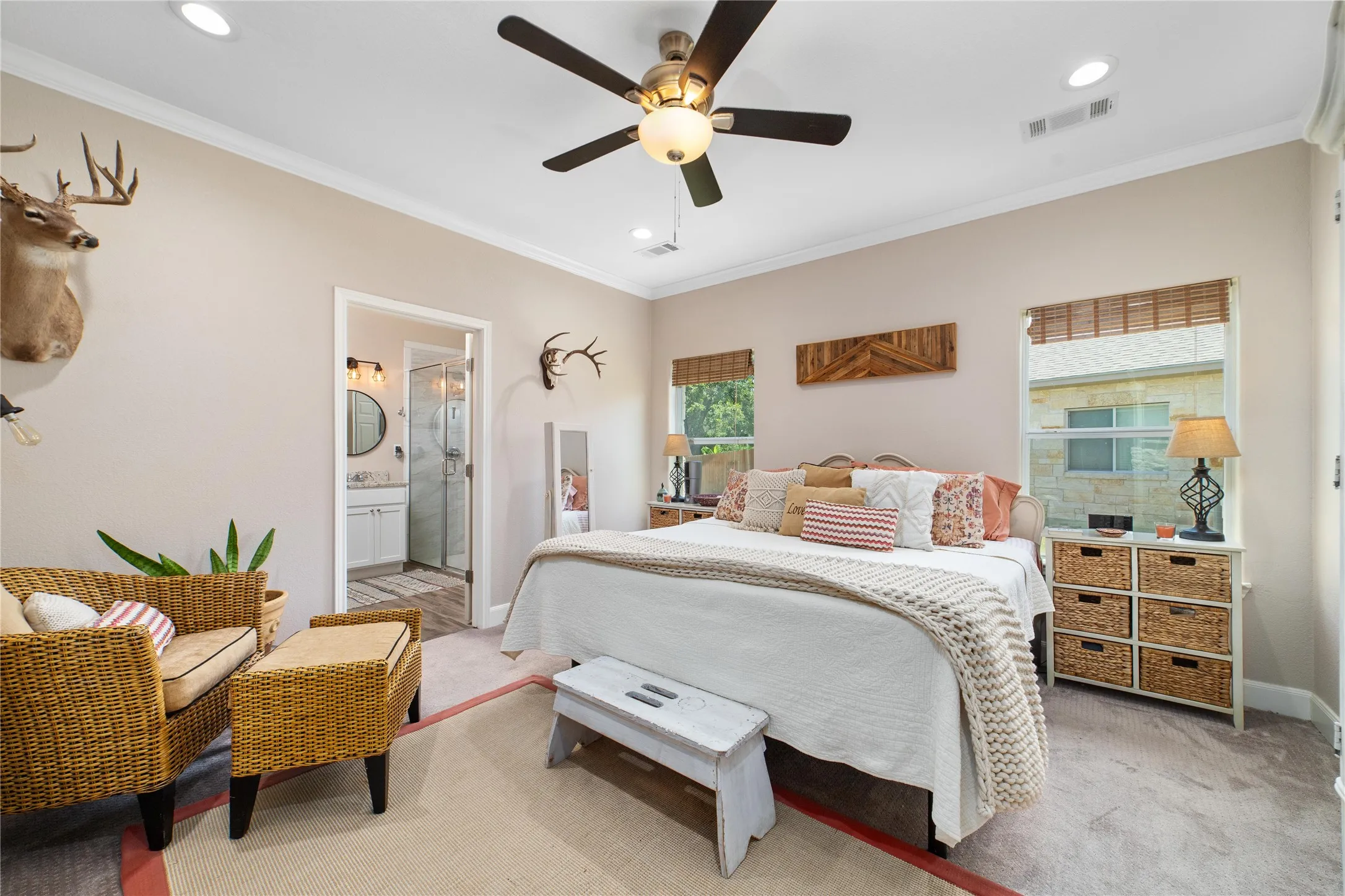 Bedroom featuring light carpet, crown molding, ceiling fan, and ensuite bathroom