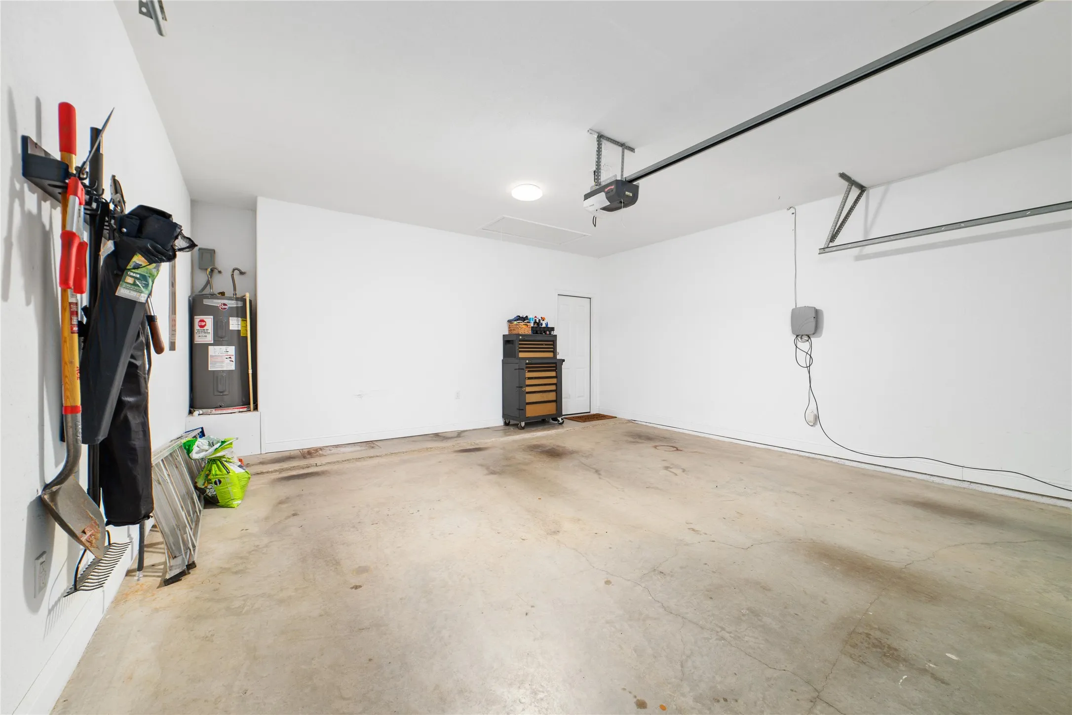 Garage featuring water heater and a garage door opener