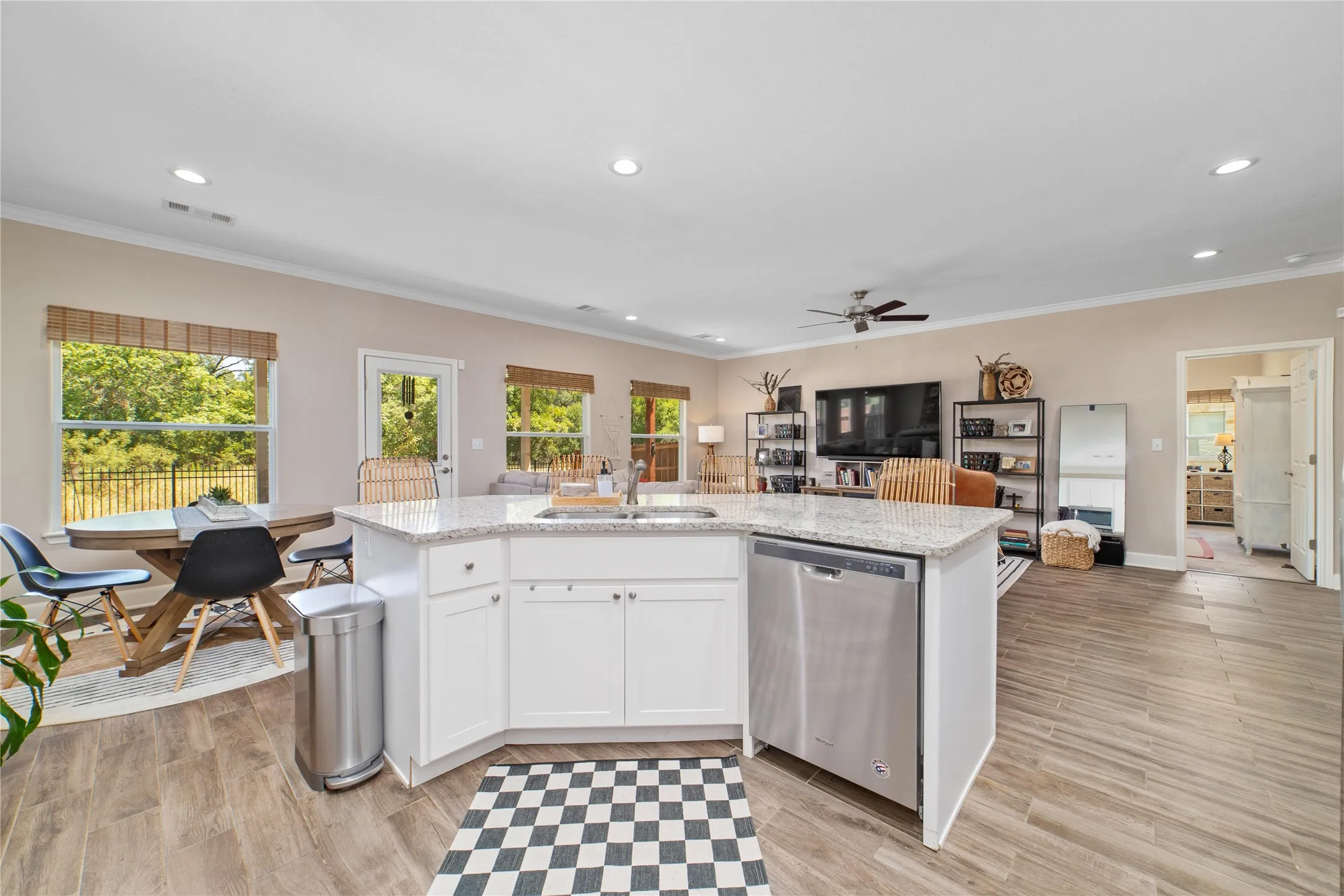 Kitchen with ceiling fan, white cabinets, crown molding, dishwasher, and sink