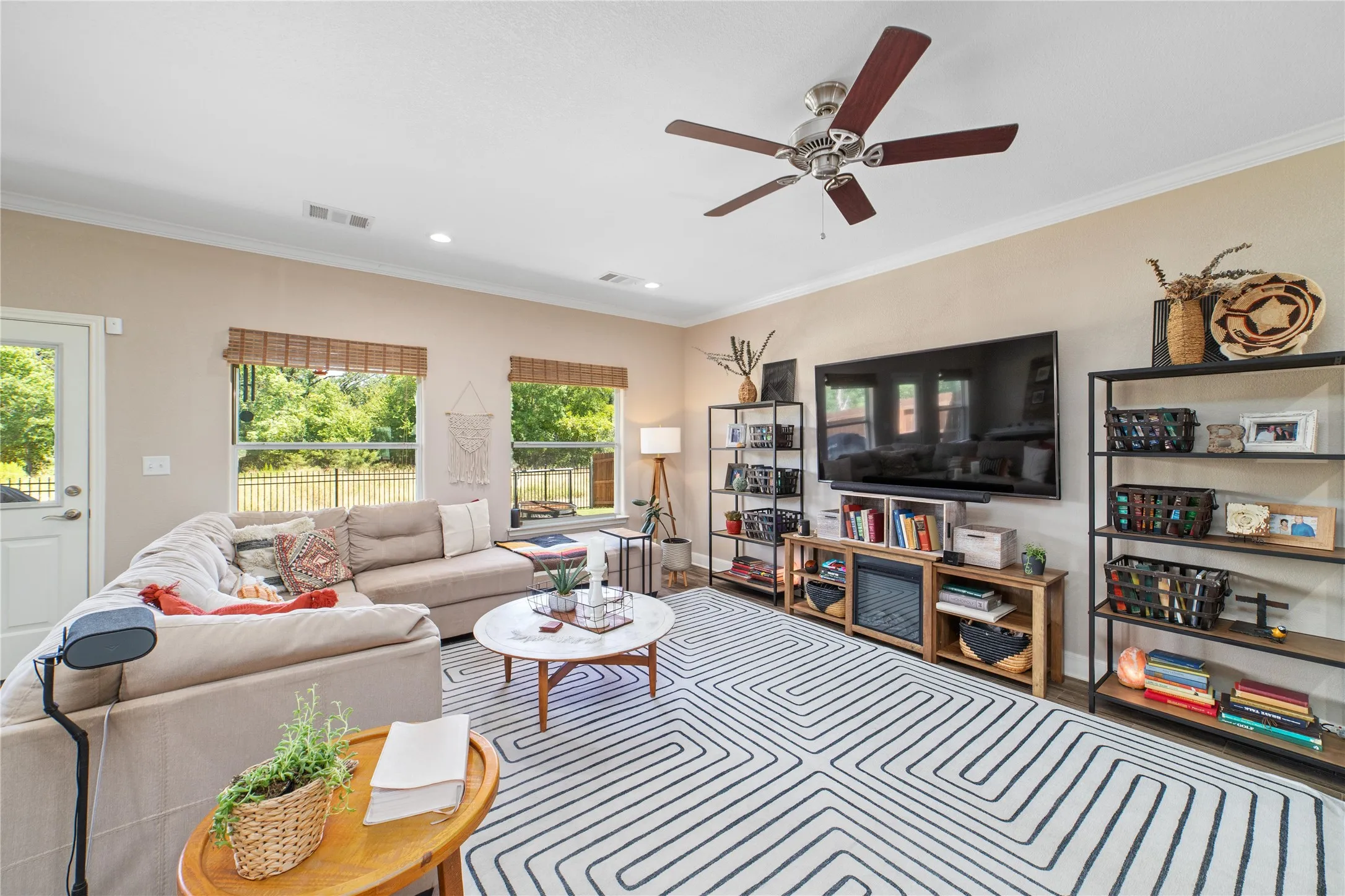 Living room with ceiling fan, crown molding, and a healthy amount of sunlight