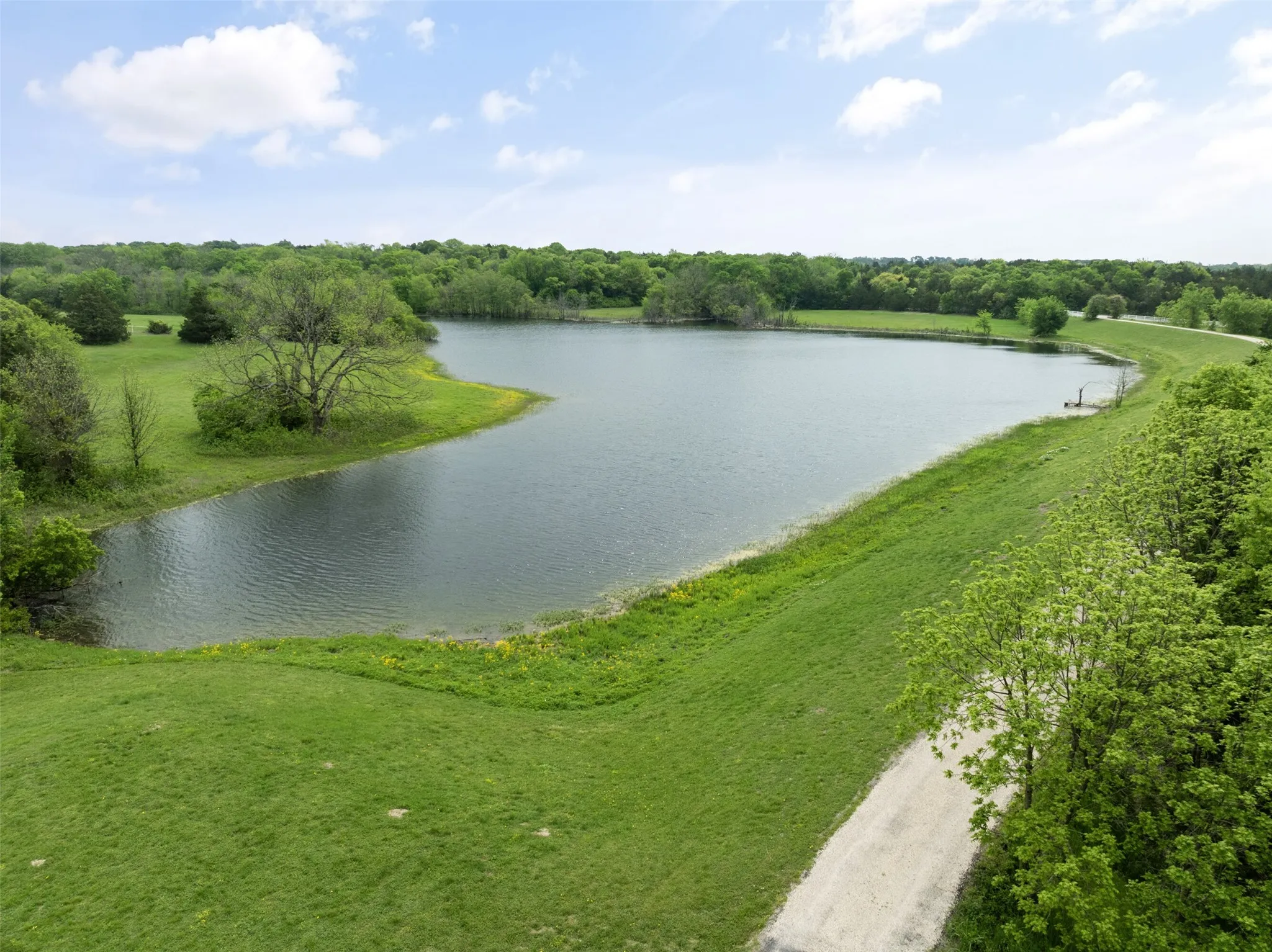 Expansive water feature with lush green embankments and surrounding mature trees