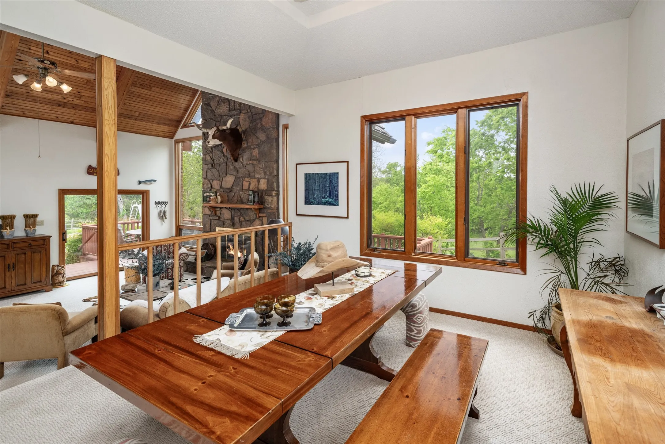 Wood-finish flooring, wood-framed windows, and stone-finish wall with hearth