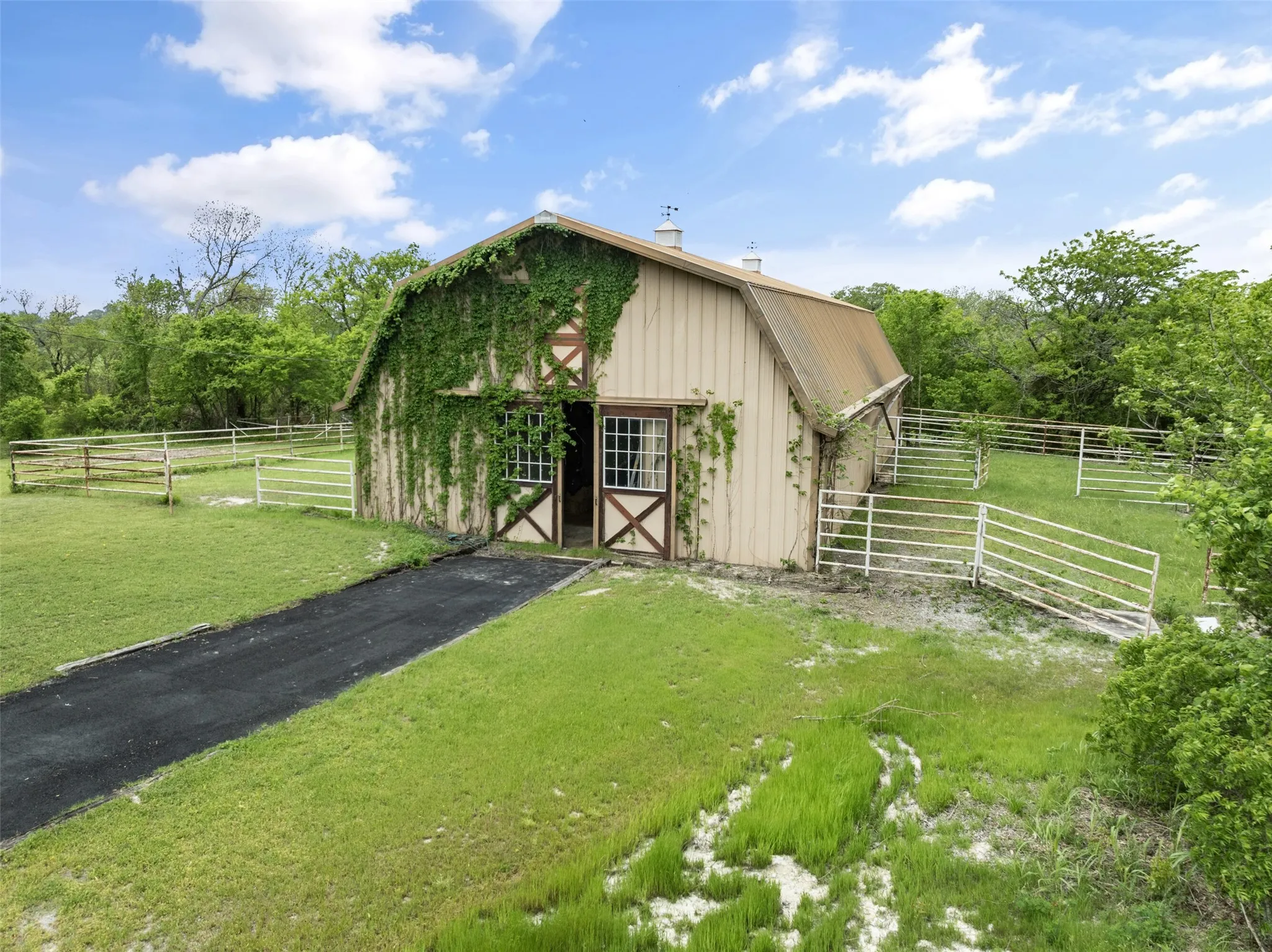Gambrel roof barn with metal siding, featuring a metal roof and double stable doors