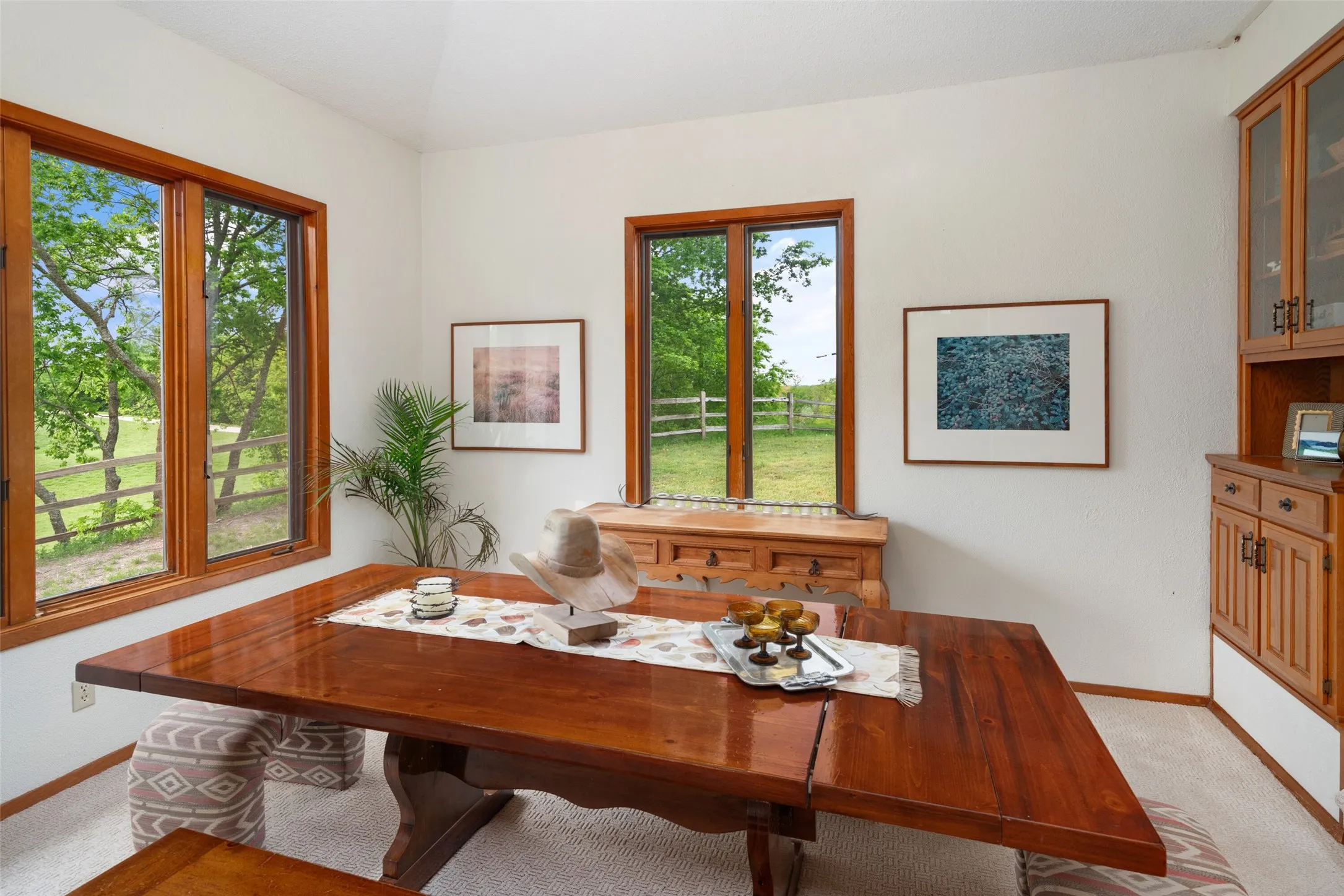 Wood-trimmed windows, built-in cabinetry with glass-front uppers, wood-finish flooring, and painted walls