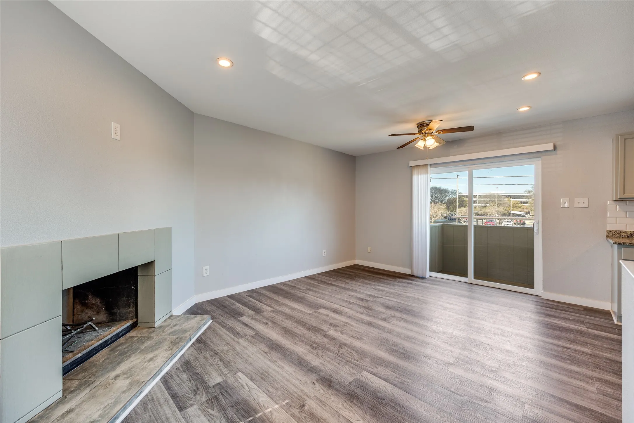 Living area featuring wood-finish flooring, a tile fireplace, recessed lighting, and a ceiling fan