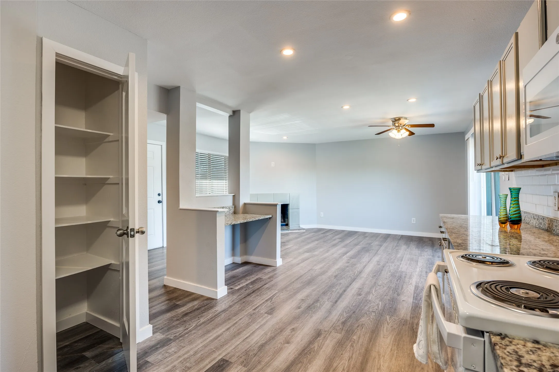 Kitchen featuring a built-in electric range, white cabinetry, and granite countertops