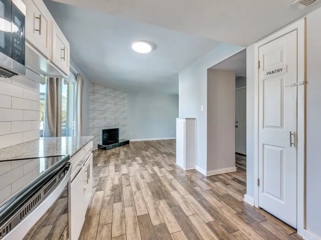 Kitchen featuring white cabinetry, stone-finish countertops, subway tile backsplash, and stainless steel appliances