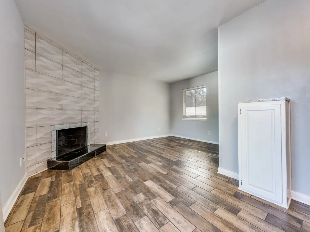 Fireplace featuring textured tile surround, black hearth, and black firebox