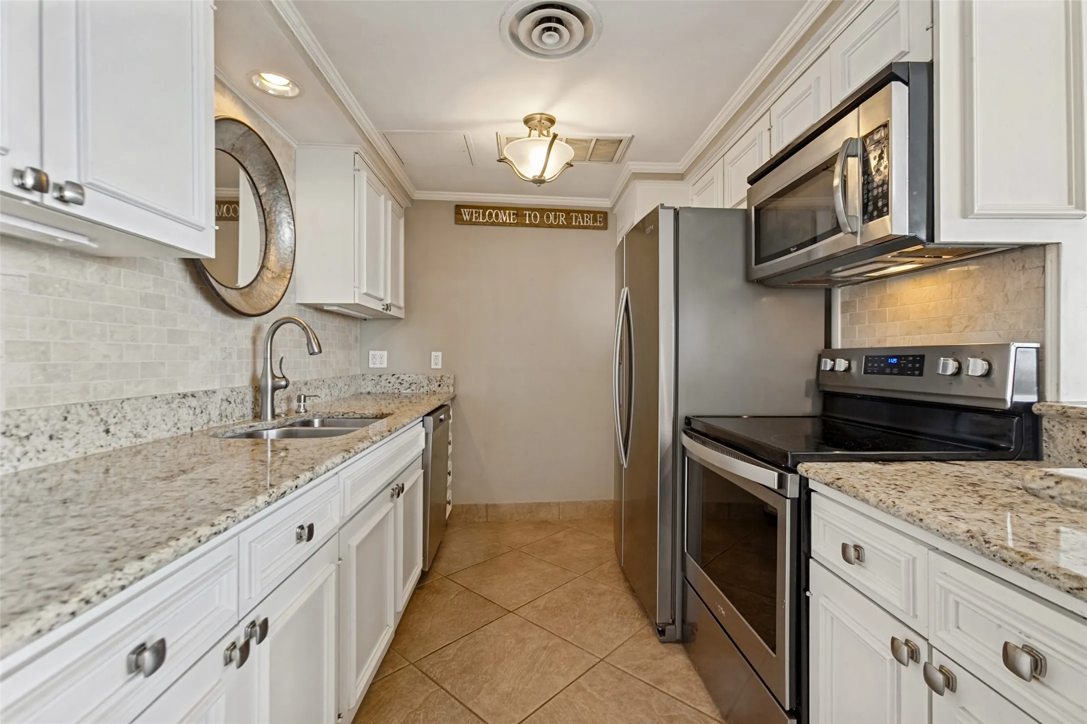 Galley kitchen has granite counter tops, tile backsplash, and a separate pantry