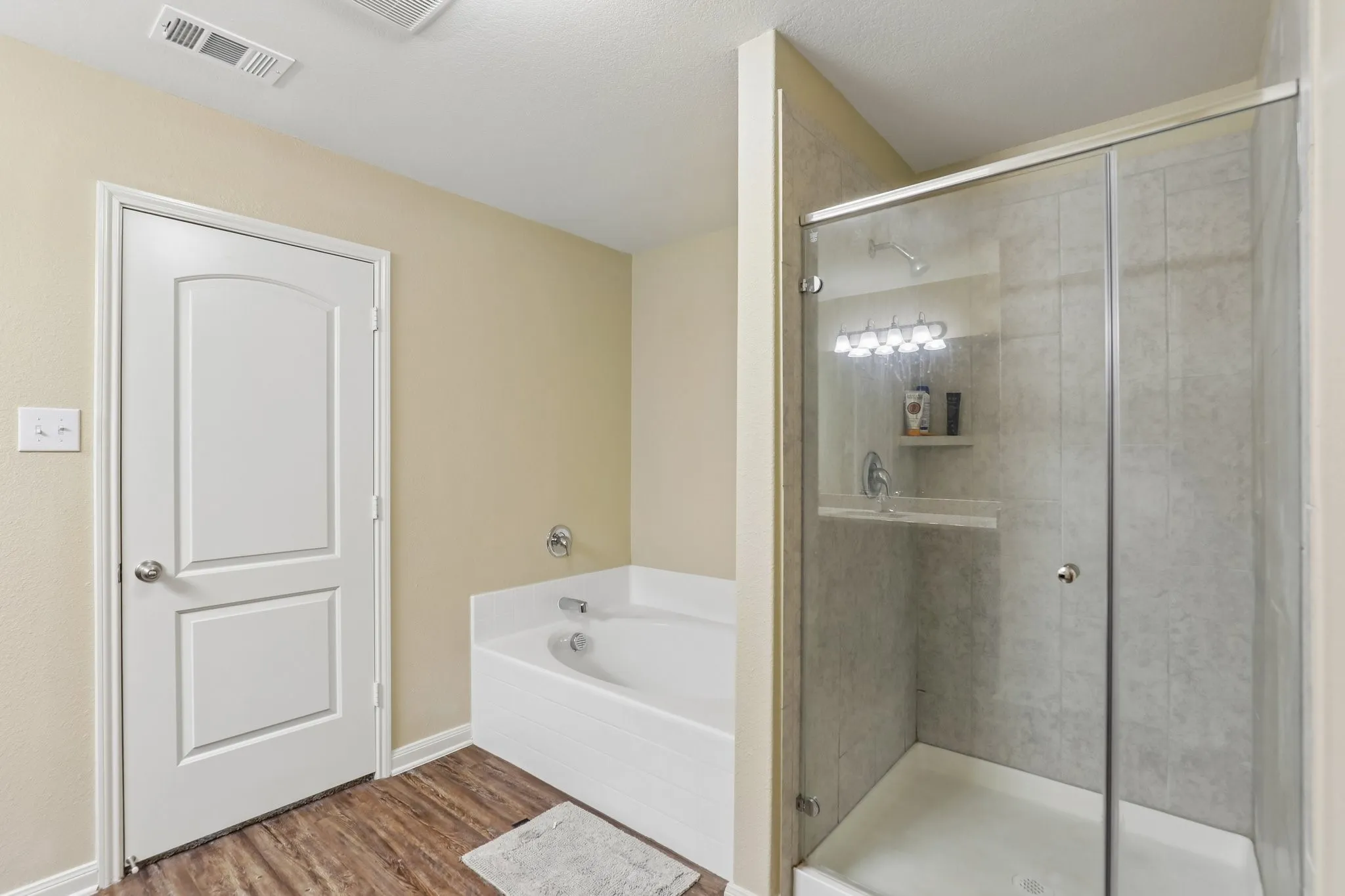 Walk-in shower with clear glass enclosure and tile surround