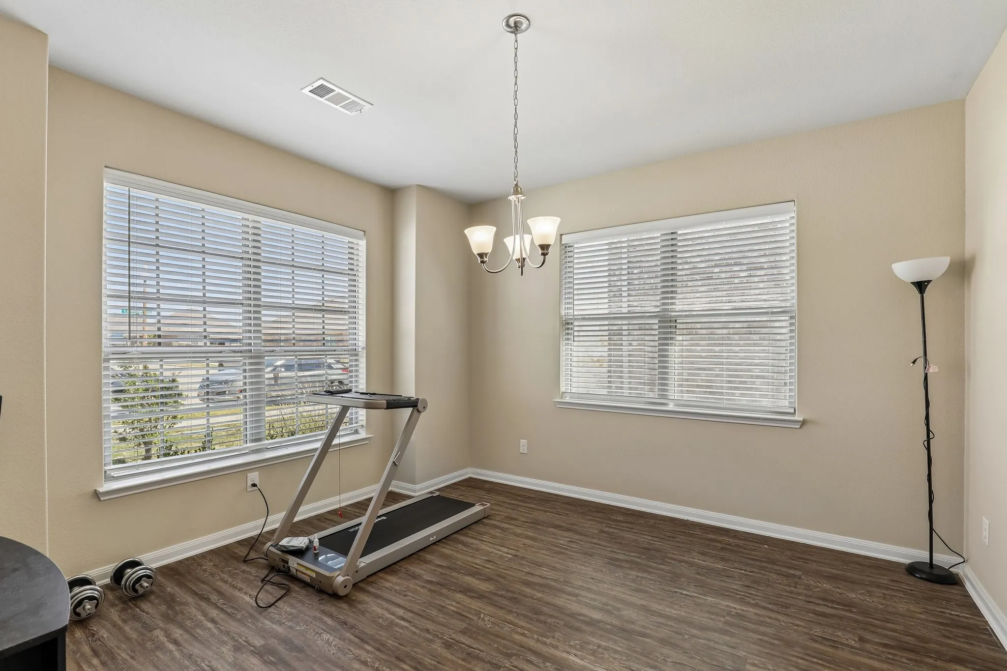 Bright, light-filled room with dual large windows featuring plantation shutters and expansive natural light