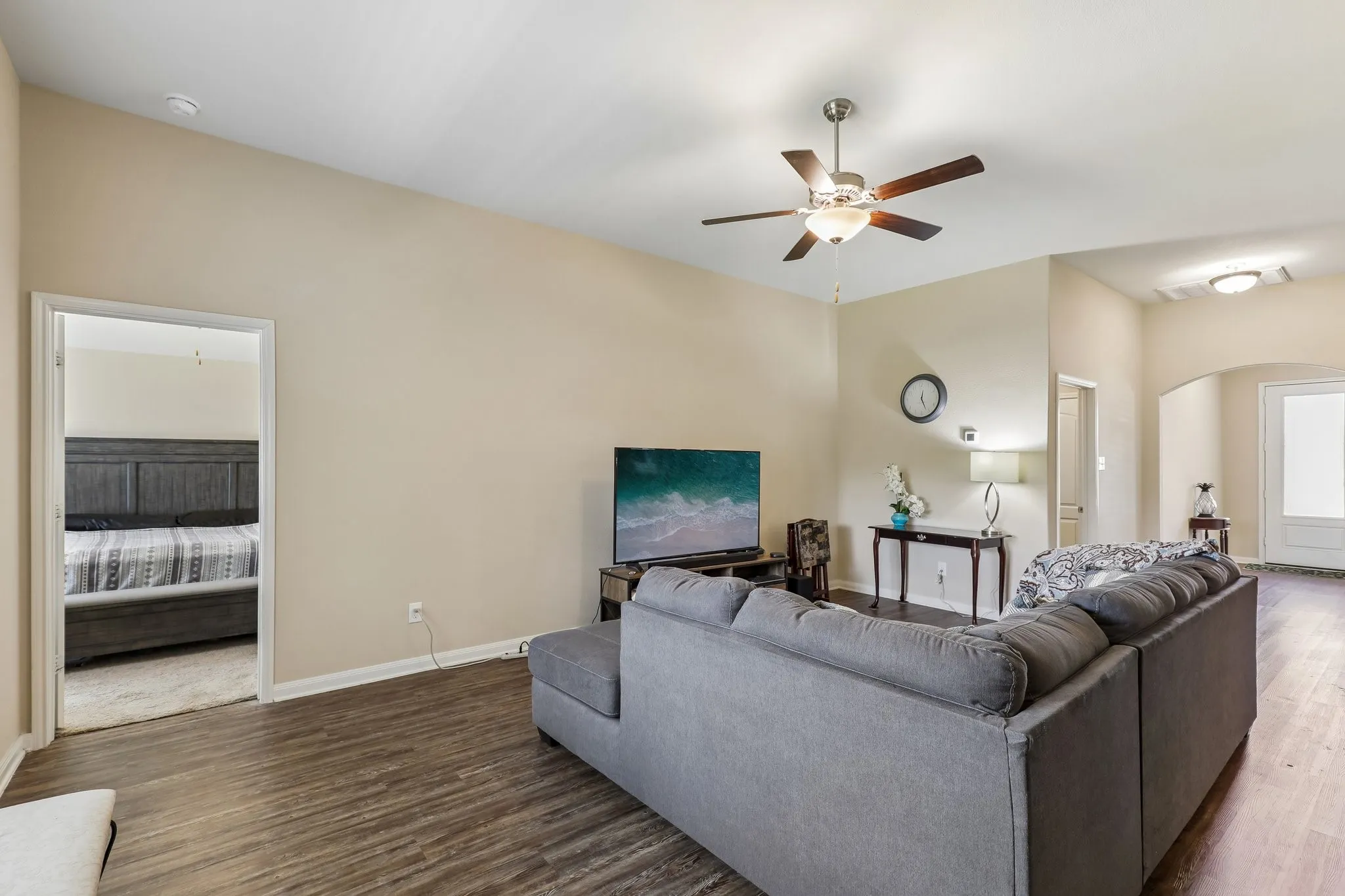 Vaulted ceiling with a ceiling fan, wood-finish flooring, arched doorway, and recessed ceiling lighting