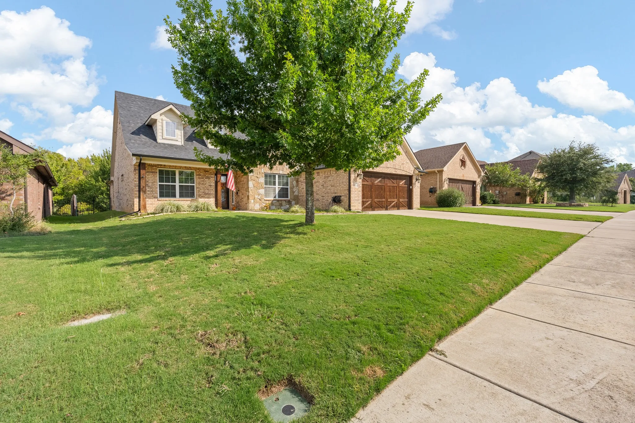 Wood-finish flooring, crown molding, and a decorative stained-glass entry door with a sidelight
